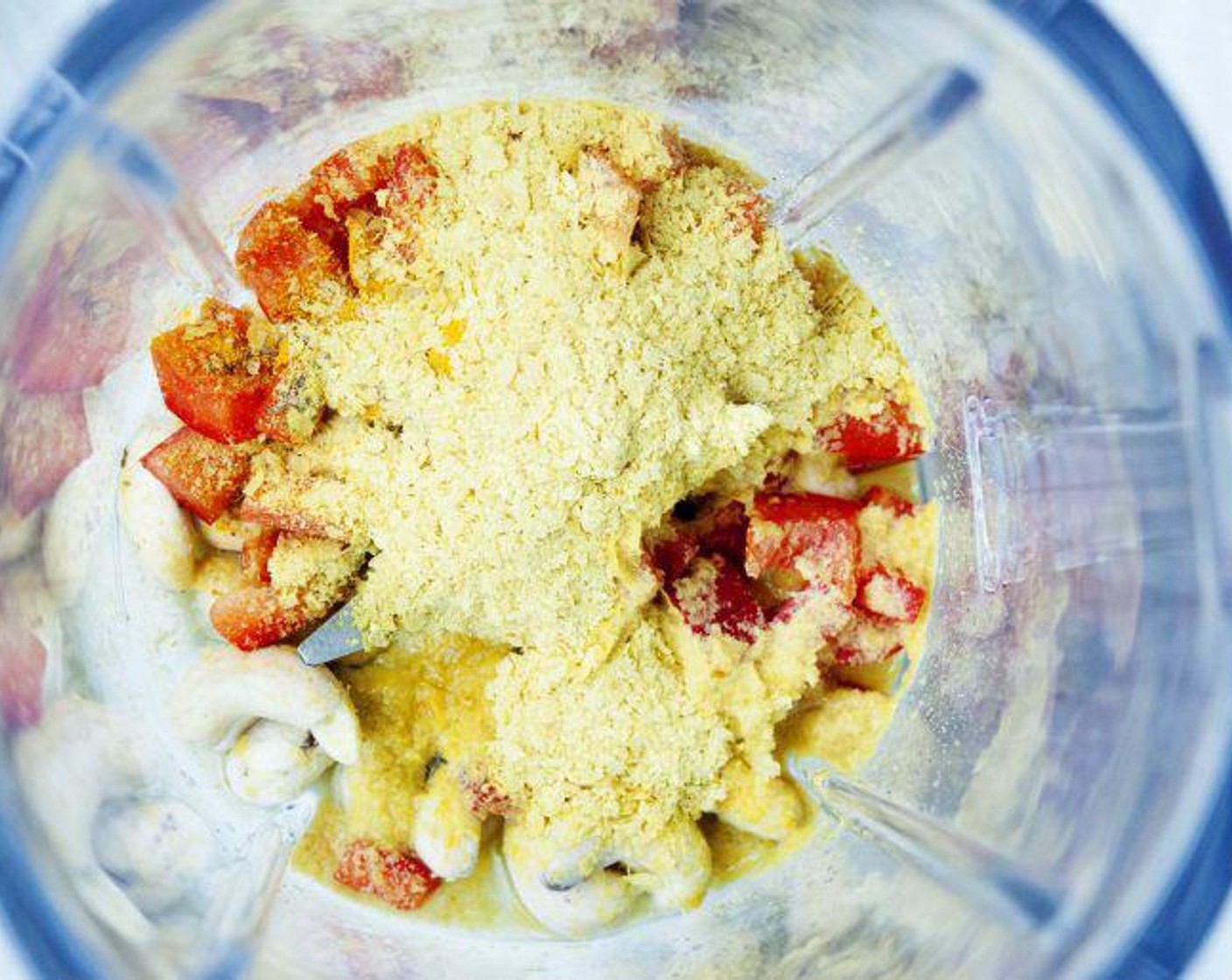 step 3 Place Red Bell Pepper (1/2), Onion Powder (1/2 tsp), Pink Himalayan Sea Salt (1/2 tsp), Cashew Nuts (1/2 cup), the juice from Lemon (1), Nutritional Yeast (3 Tbsp), Ground Turmeric (1 tsp), and Water (as needed) in the blender.