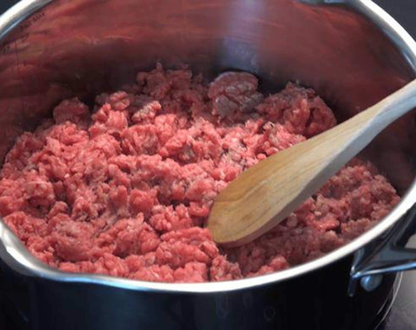 step 2 In a saucepan add Olive Oil (1 Tbsp) and Ground Beef (1.1 lb). Using a wooden spoon break apart the minced beef and cook until brown.