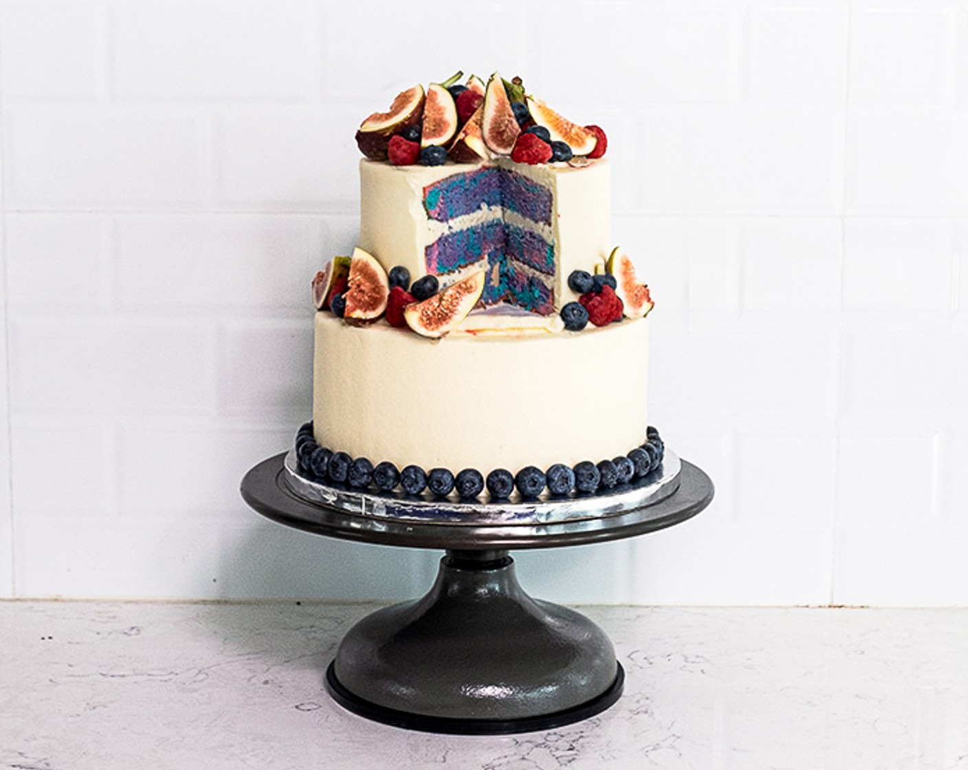 Tiered Cake with Multi-Colored Layers and Fresh Berries