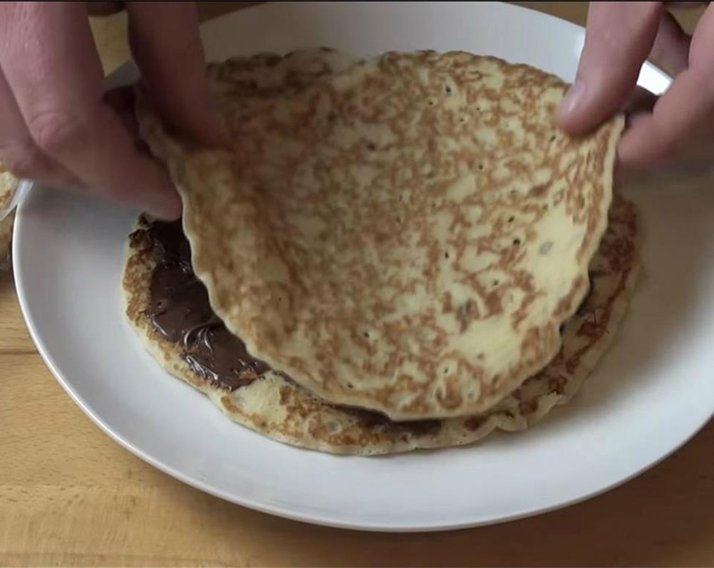 step 4 Place the second layer of crepe and repeat until you've used all of the crepes making sure the top layer of the cake doesn't have any nutella.