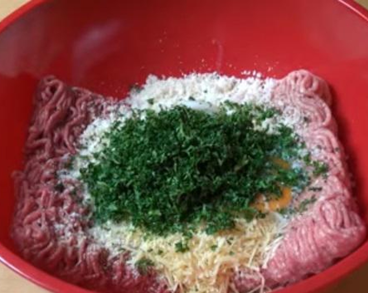 step 1 Into a mixing bowl, add in the Ground Beef (1.1 lb), Pork (1.1 lb), Simply Organic Garlic Powder (1 tsp), Breadcrumbs (1 cup), Parmesan Cheese (4 Tbsp), Eggland's Best Classic Eggs (2), Milk (1/2 cup), Fresh Parsley (1/2 cup), Salt (to taste), and Ground Black Pepper (to taste). Using your hands mix everything together.