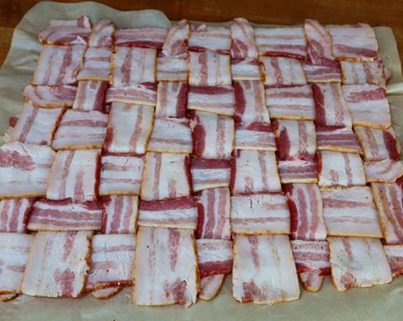 step 5 Lay out the Thick-Cut Bacon (2 lb) on a sheet of parchment paper and fold every other piece weaving strips across into a “basket weave” pattern.