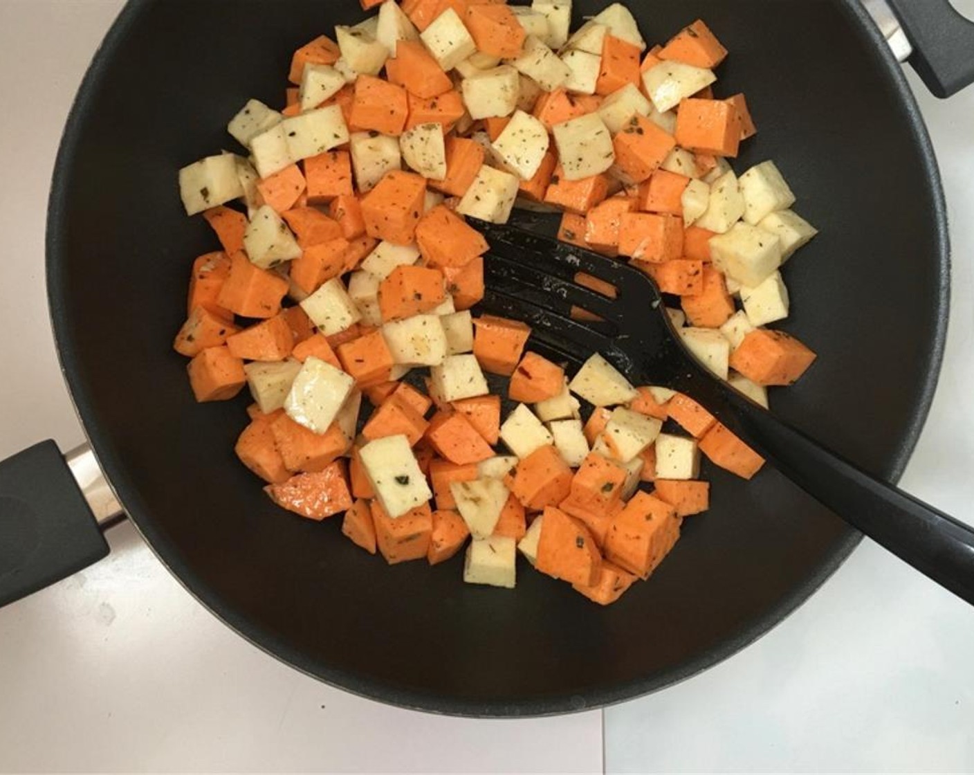 step 4 Stir the potatoes well. Place a wok or large non-stick frying pan over medium-high heat. Once the pan is hot, add the sweet potato mixture to it. Stir fry the potatoes for 12 to 15 minutes.