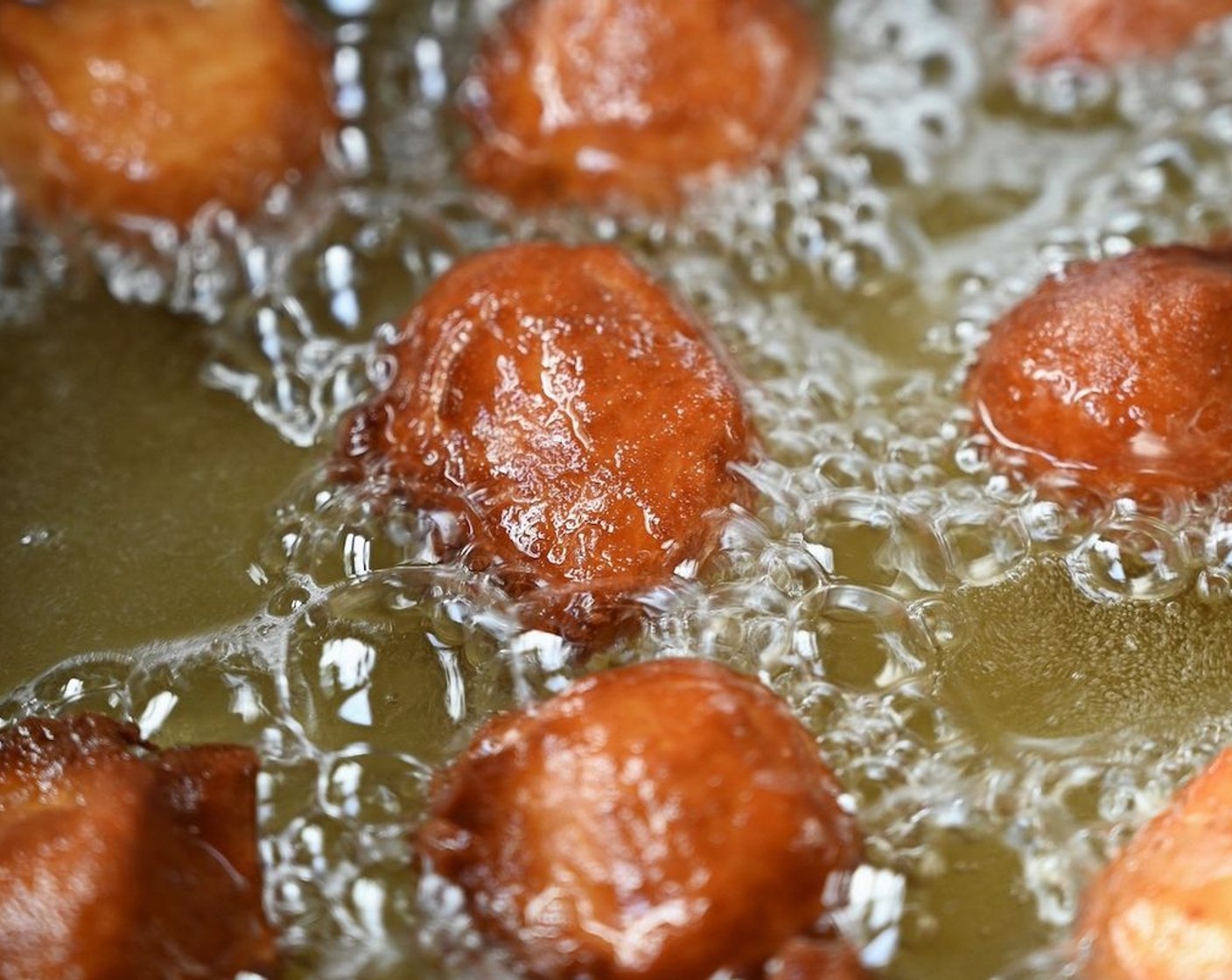 step 4 Using two oiled spoons, scoop up dollops of the dough and deep-fry in batches until golden brown. Place on a kitchen towel to drain excess oil.