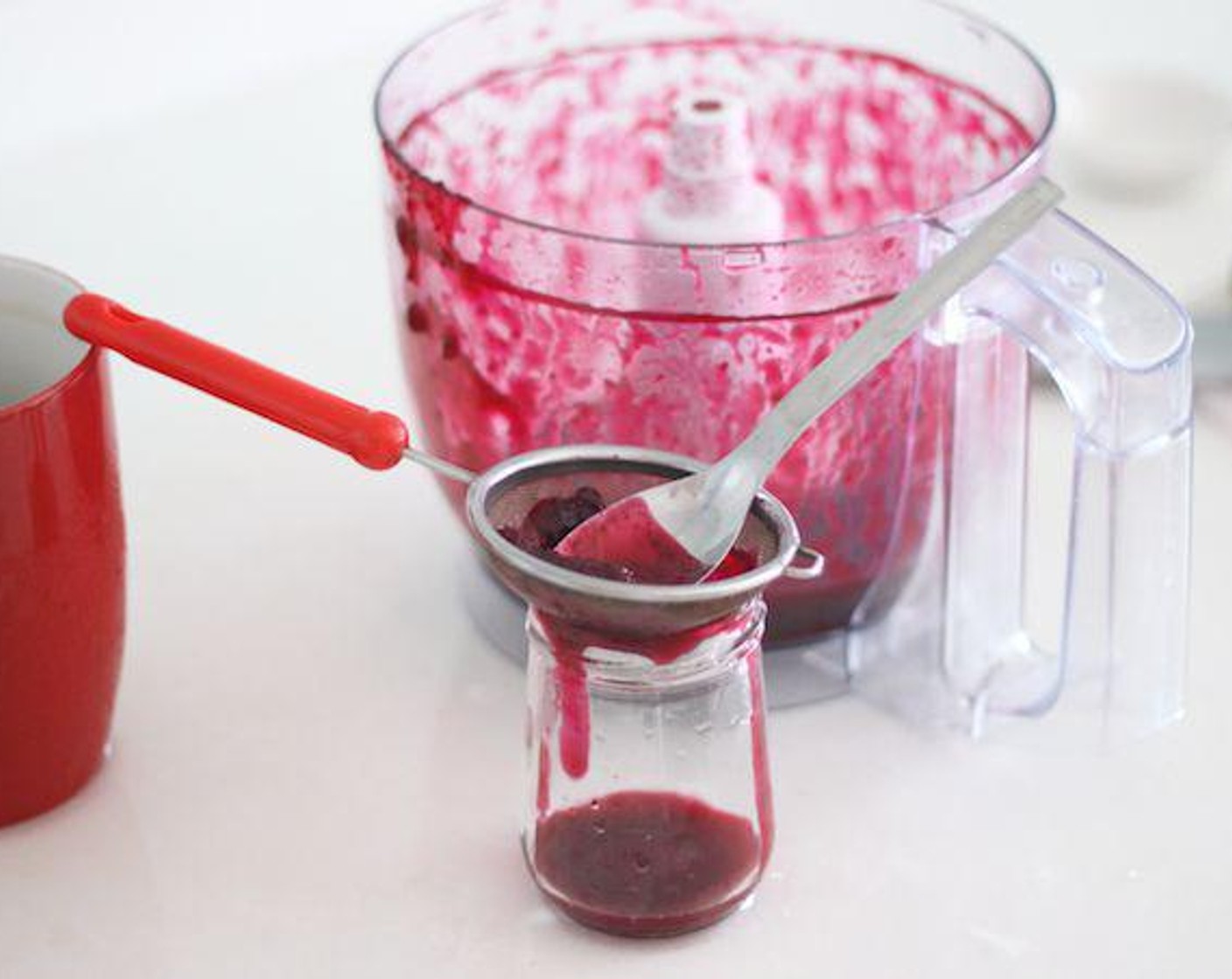 step 4 Strain the mixture into a little bottle or jar using a fine sieve. Press it down with a spoon to help the liquid through.