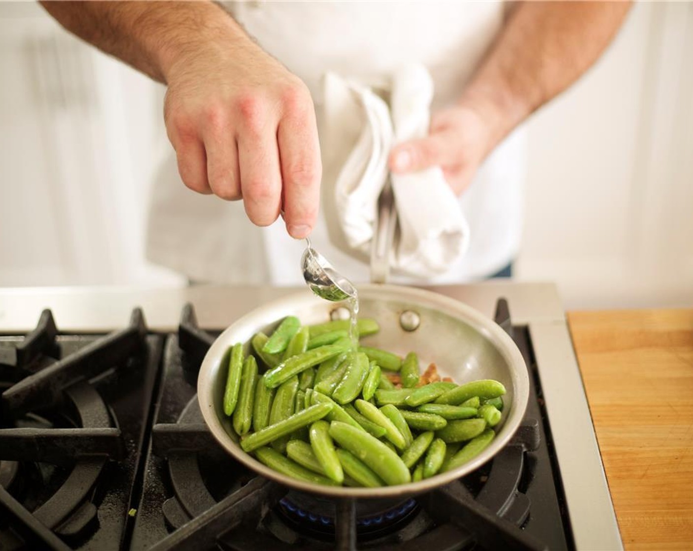 step 10 Add sliced garlic and saute for 30 seconds, being careful not to burn the garlic. Add sugar snap peas, 1/4 teaspoon salt and pinch of pepper; stir and cook for 2 minutes. Add 1 tablespoon water, cover and cook for 2 more minutes and remove from heat.