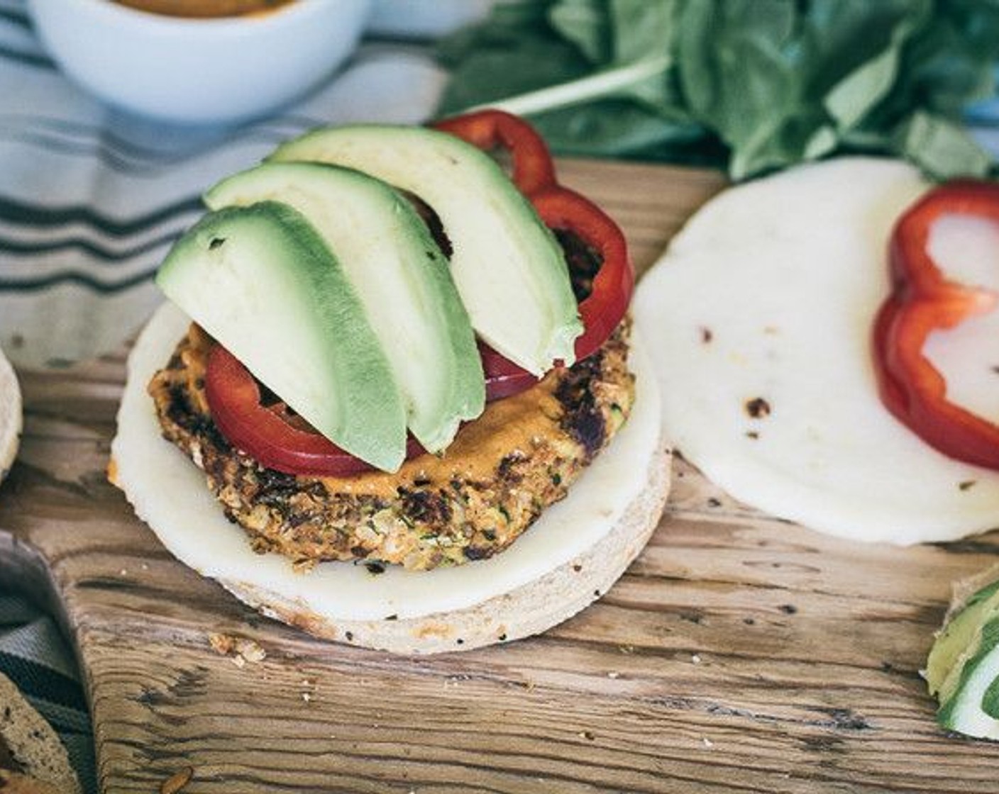 step 12 Assemble your veggie burgers using your preferred choice of Buns (to taste), then top patties with Sriracha Avocado Sauce and whatever toppings you prefer. We used Red Bell Peppers (to taste), Fresh Spinach (to taste), Cheese (to taste), Onions (to taste), and sliced Avocados (to taste).