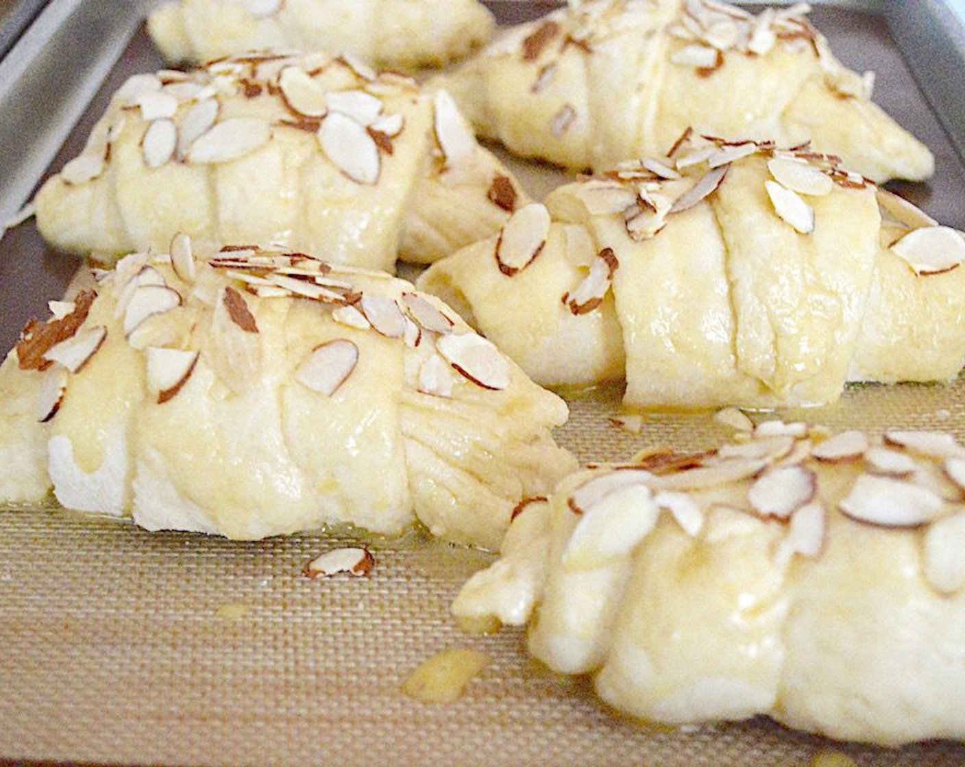 step 14 Whisk the Eggland's Best Classic Egg (1), Almond Extract (1/4 tsp), and Water (1 dash) together in a bowl and brush it really generously on each formed croissant. Sprinkle each croissant with Sliced Almonds (to taste) and lightly press them in so that they stick to the egg wash.