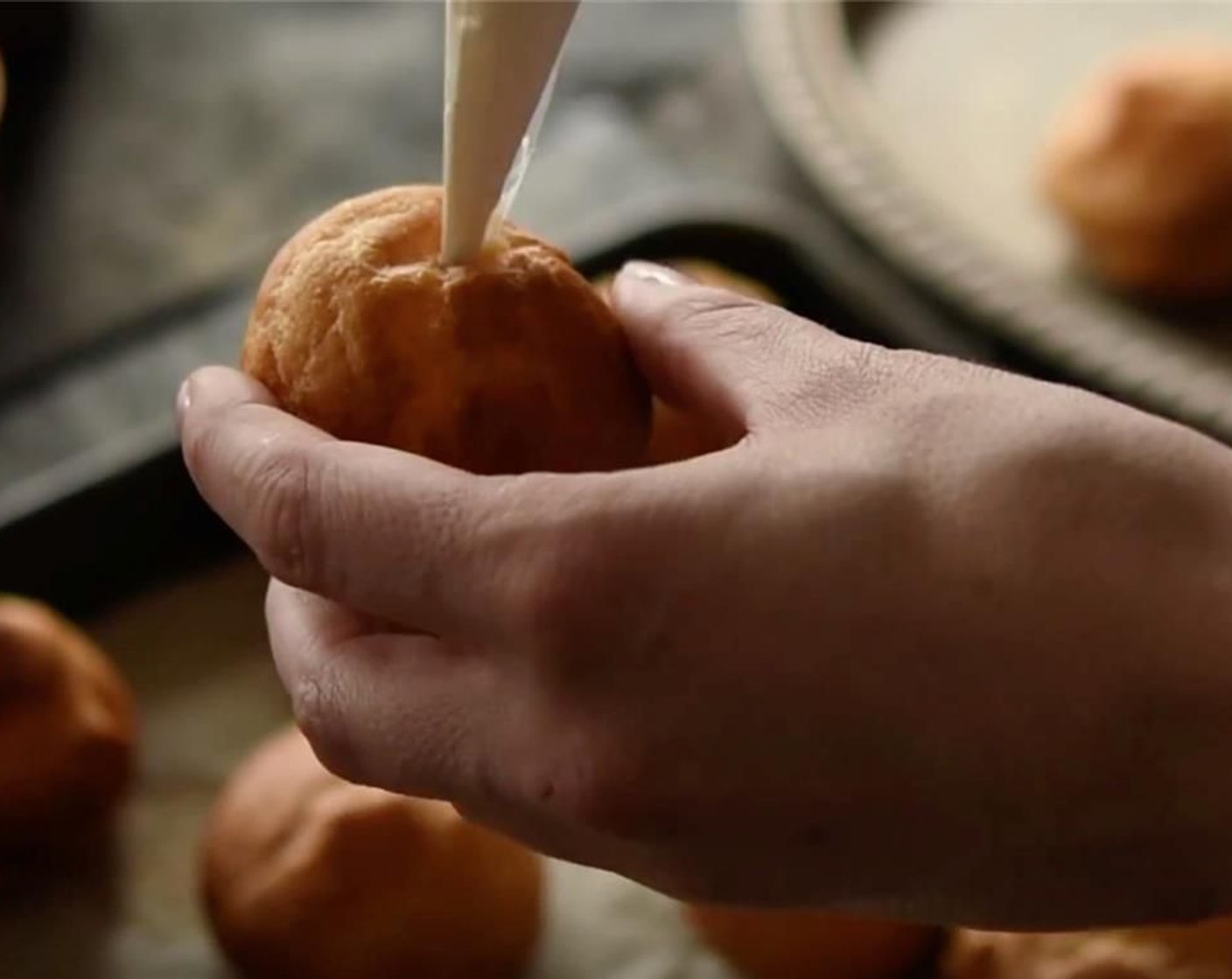 step 24 To assemble the profiteroles, pipe a small amount of the ginger and lime curd mixture into each choux bun.