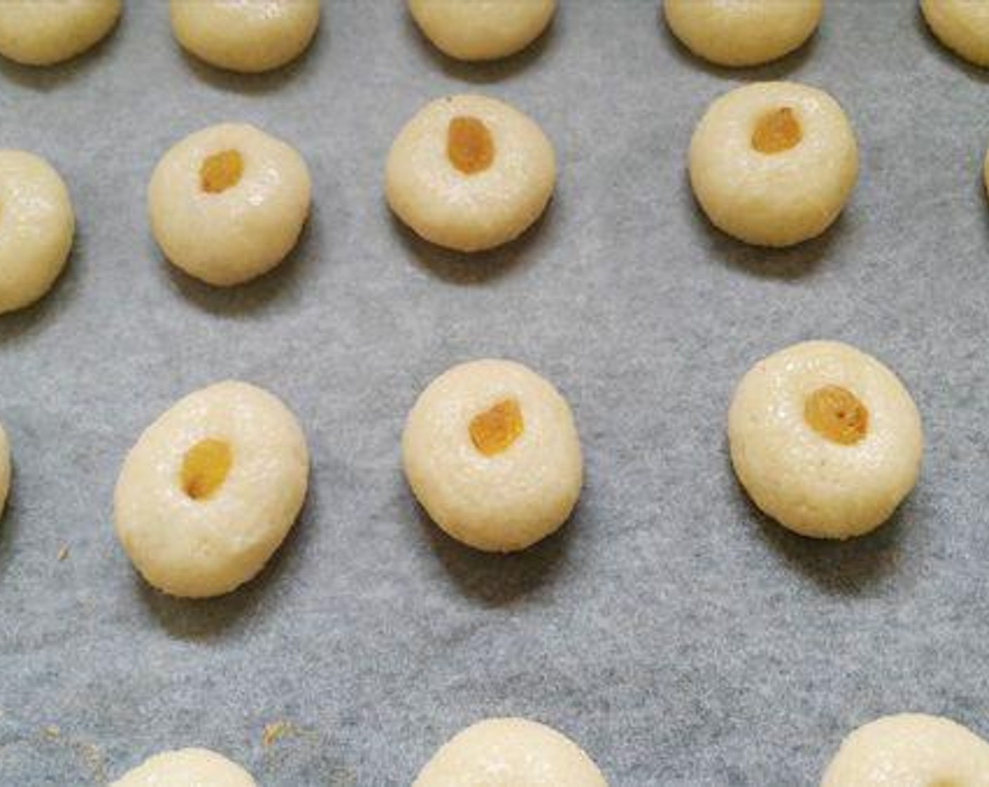 step 4 Arrange the cookies on a baking tray and place Raisins (to taste) on each cookie ball and bake for about 8 to 10 minutes.