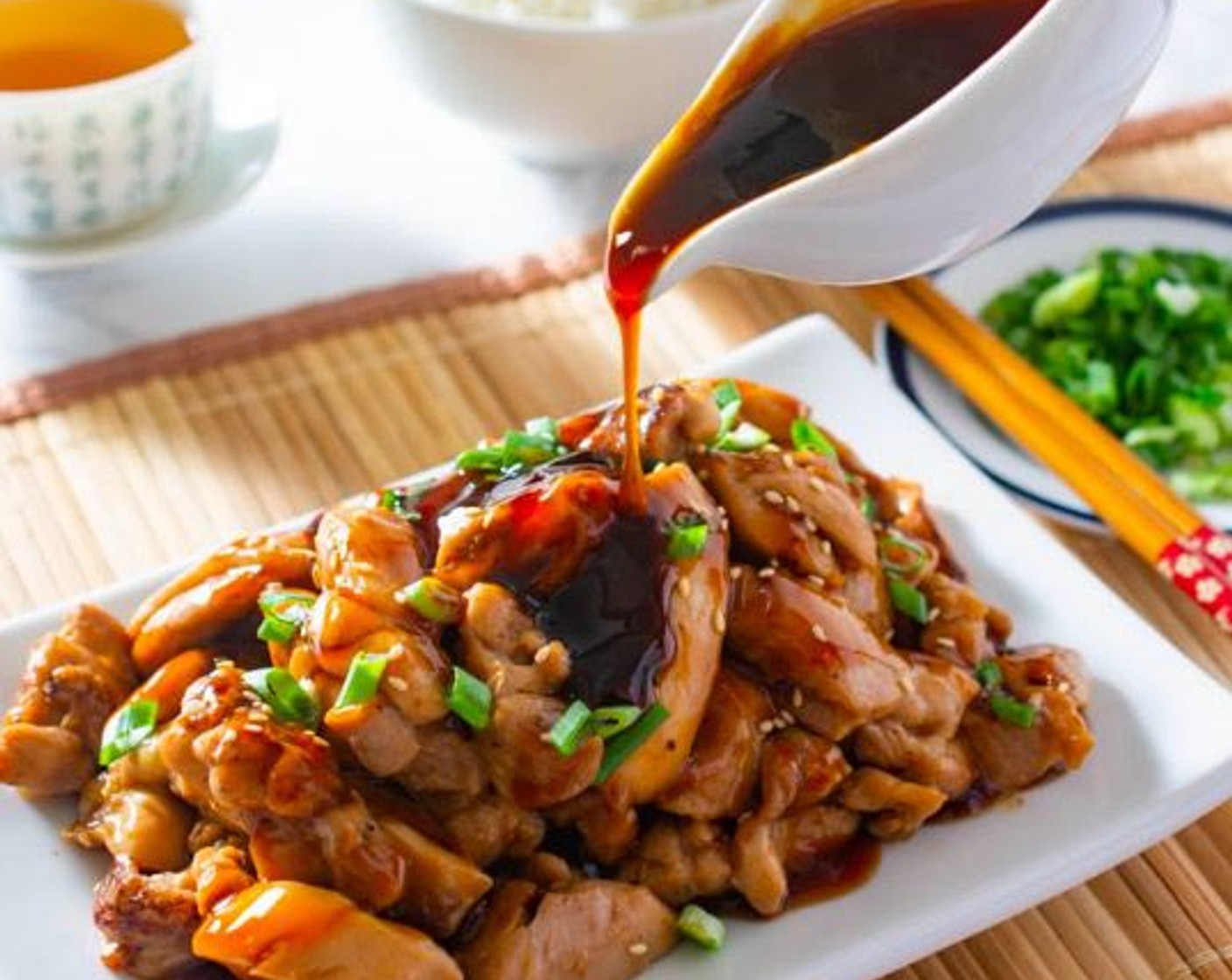 step 7 Transfer chicken to a serving plate. Garnish with Scallions (to taste) and Toasted White Sesame Seeds (to taste). Serve the chicken and sauce separately, or drizzle the sauce over the chicken. Enjoy!