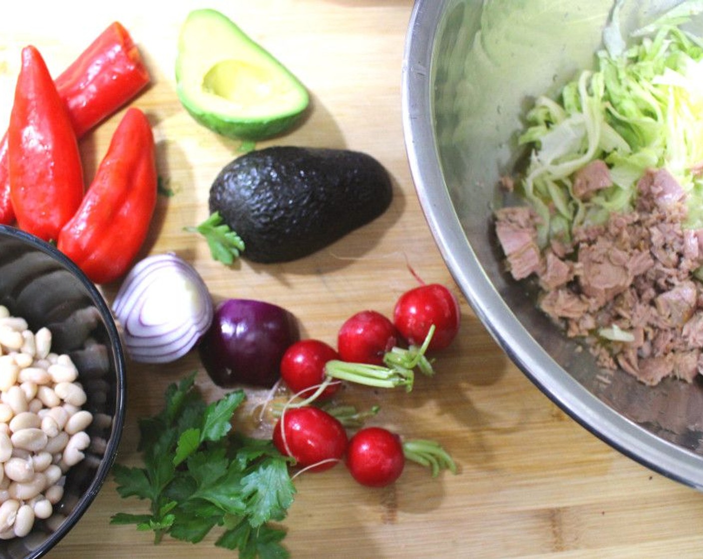 step 1 In a large bowl mix together Iceberg Lettuce (1 cup), White Beans (1 cup), Canned Tuna (1 cup), Avocado (1), Baby Red Radish (5), Fresh Cilantro (4 Tbsp), and Red Onion (1).
