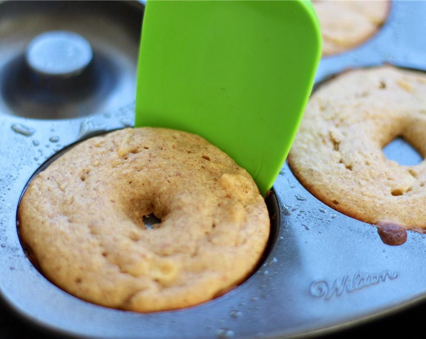 step 8 Let cool in the pan for 5 minutes. Slide a thin spatula around the edges of the doughnuts to help loosen them out.