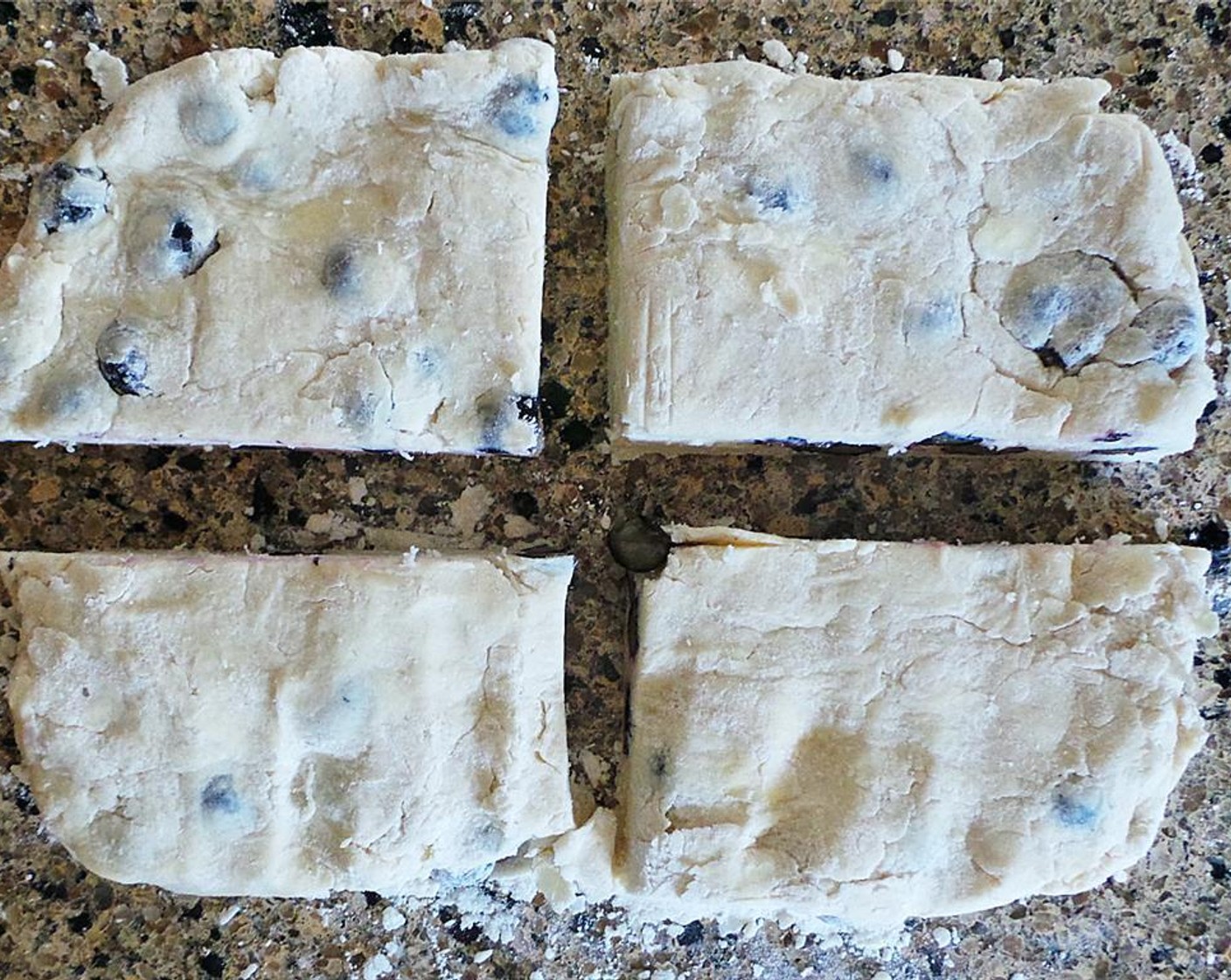step 5 Lay on a floured surface and press into a rectangle. Cut the dough in half, then in half once more to create four squares. Cut each square in half on a bias to create a triangular scone shape.