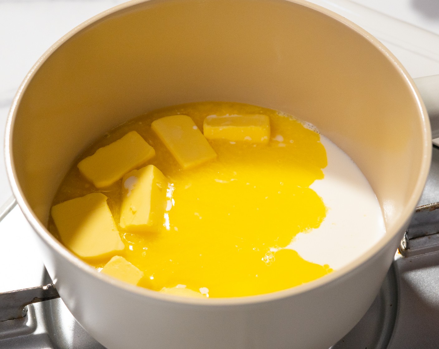 step 8 Prepare the frosting by adding Butter (1/2 cup) and Milk (1/4 cup) in a saucepan, and bringing it to a boil. Remove from heat.