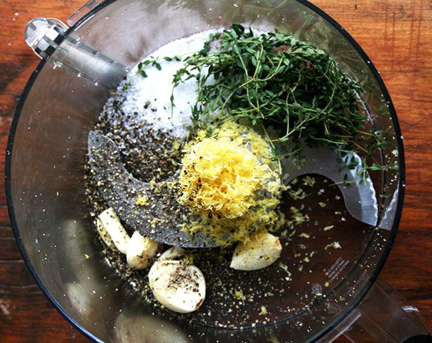 step 3 Place the Garlic (4 cloves), Fresh Thyme Leaves (1 handful), Lemon (1), Kosher Salt (1 dash) and Ground Black Pepper (1 dash) (or a few large cracks on the grinder) in a food processor fitted with the steel blade.