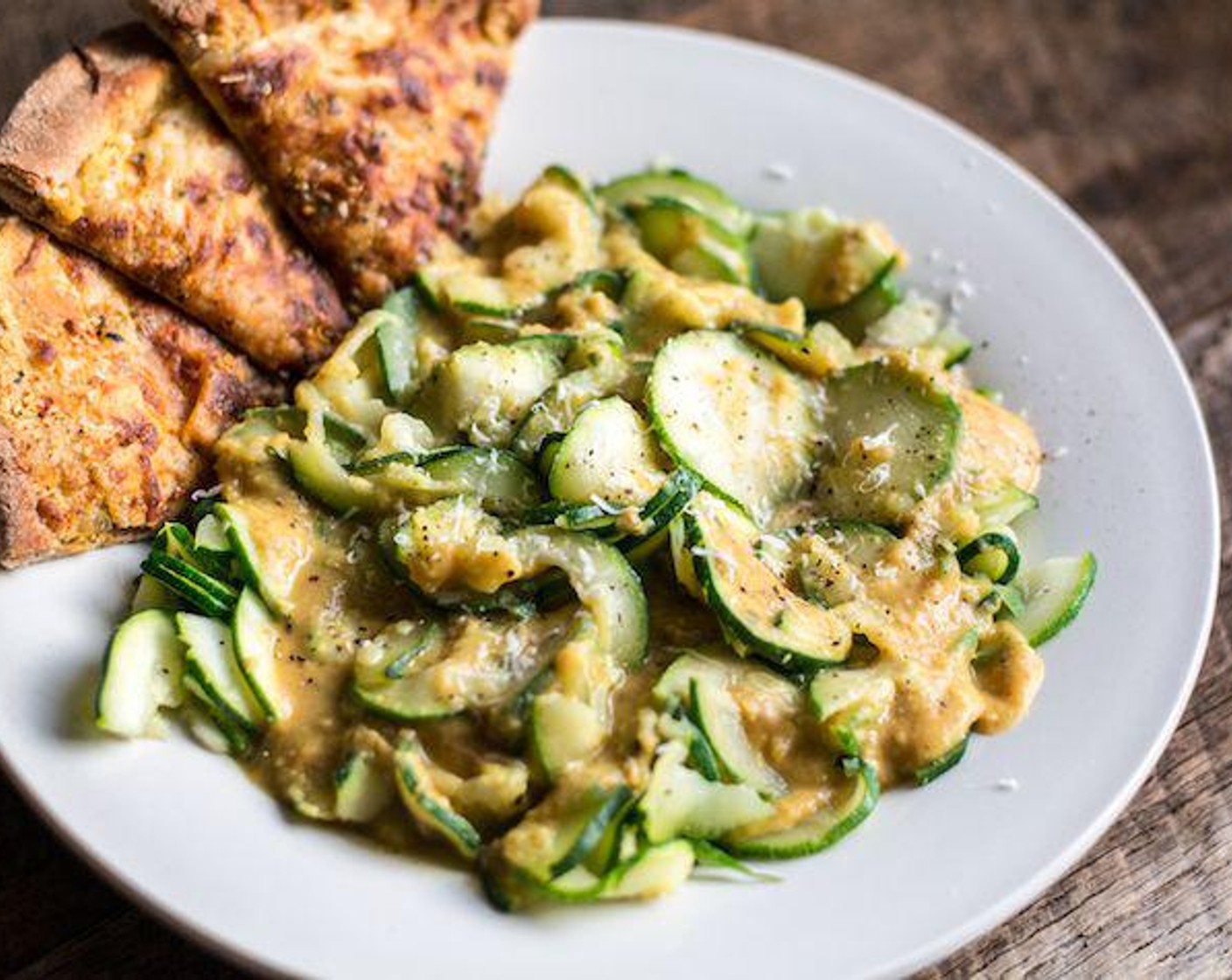 step 6 Divide zucchini into two bowls, add cooked sauce, top with additional Romano Cheese (to taste) and Freshly Ground Black Pepper (to taste), and serve.