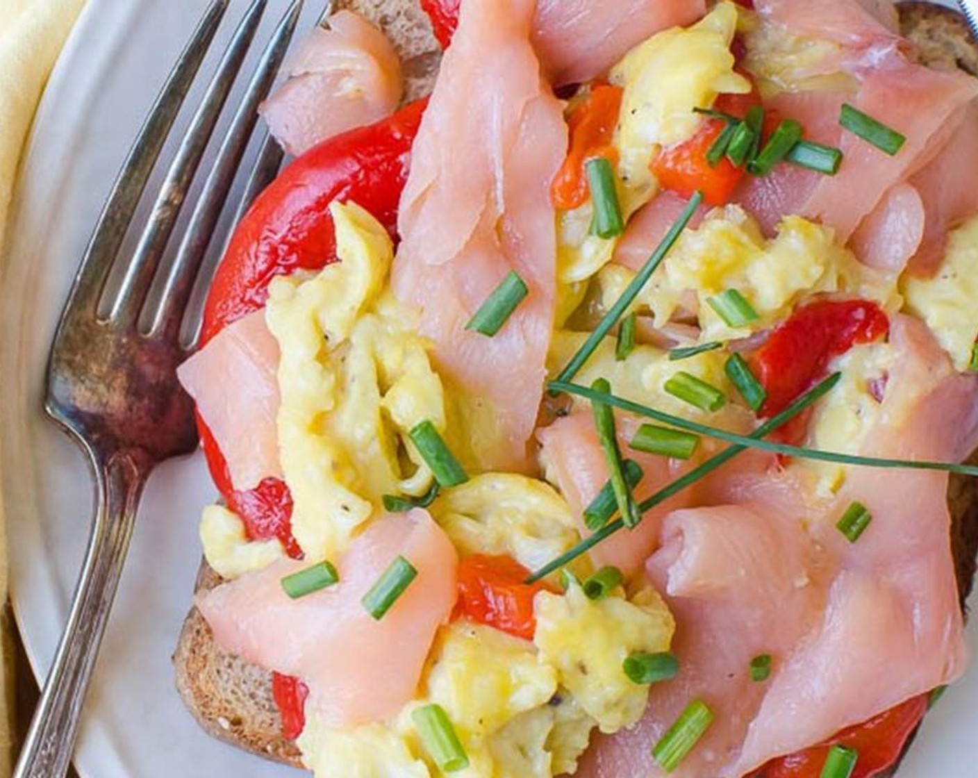 step 3 Place the Whole Wheat Bread (2 slices), top with Red Chili Pepper (1) spoonfuls of soft egg and a few curls of Smoked Salmon (4 oz). Sprinkle with minced Fresh Chives (to taste). Serve and enjoy!