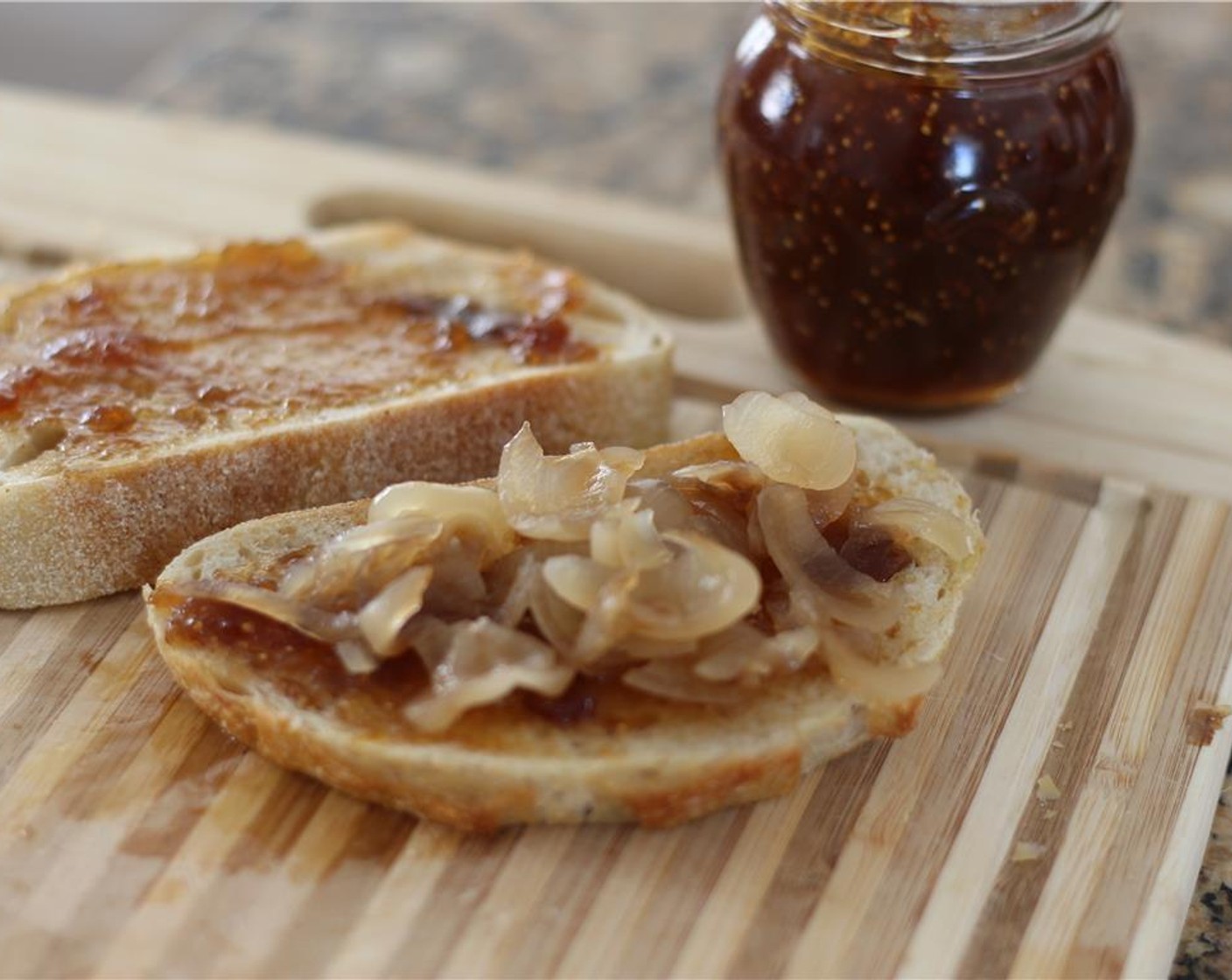step 3 Flip the bread slices over and spread on a spoonful of Fig Spread (1/4 cup). Top with a layer of onions.