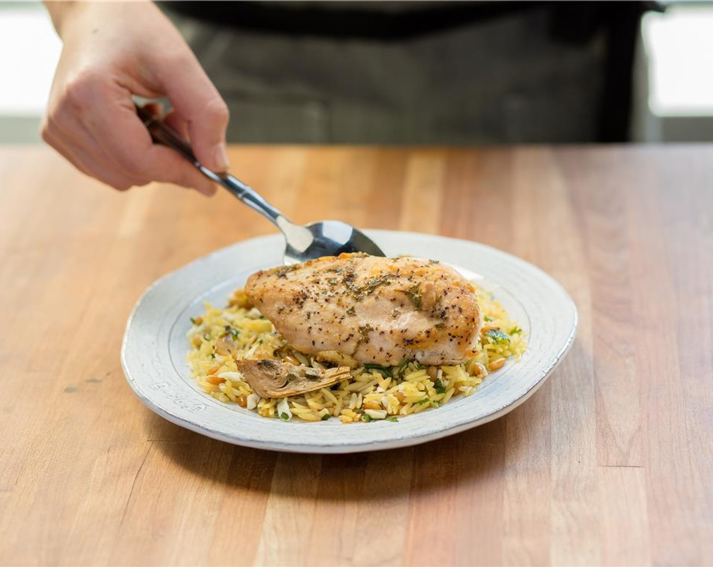 step 16 In the center of two plates, place the pasta. Place chicken on top of the orzo, and top with artichoke sauce.