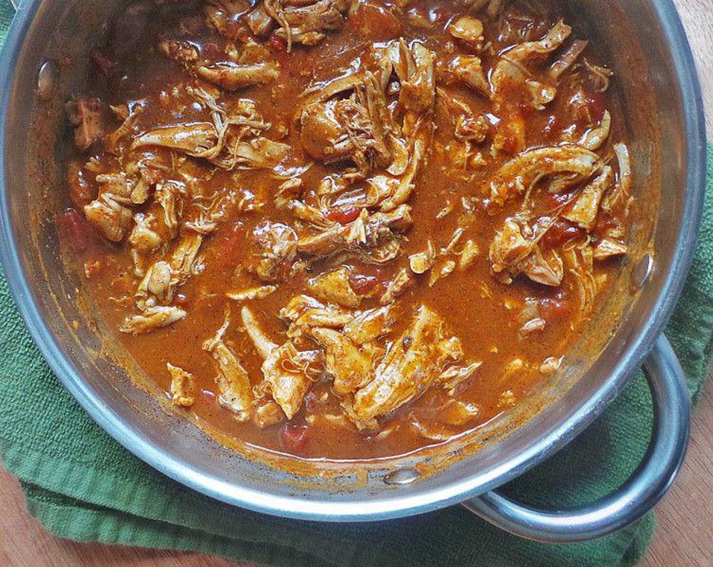 step 6 Transfer thighs to enchilada sauce and add the Diced Tomatoes (1 can). Cover and simmer for 45 minutes. When finished, the chicken will be fork tender and fall right off the bone. Discard the bone and skin. Season chicken with Kosher Salt (to taste) as desired.