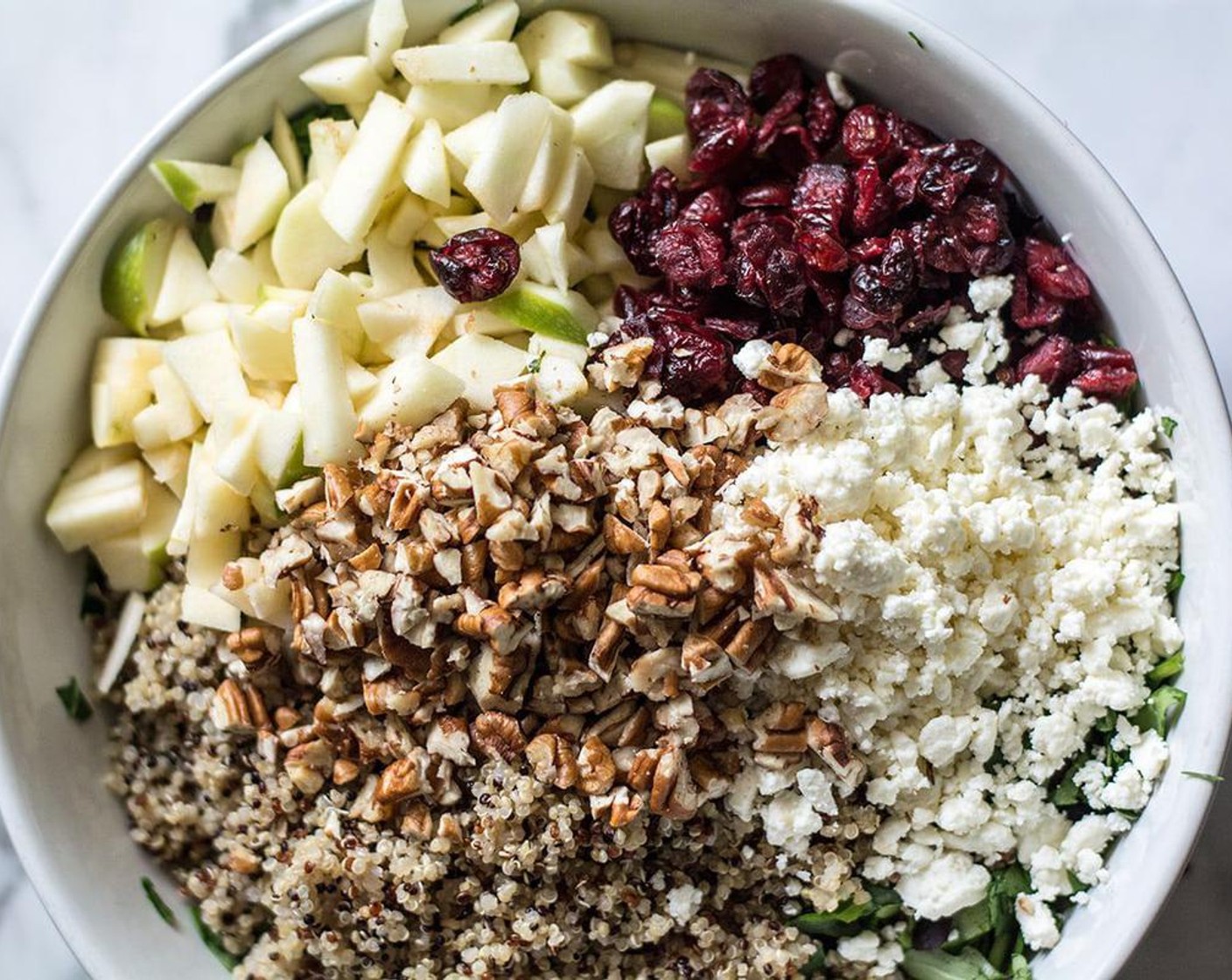 step 3 Add greens to large bowl, top with cooled quinoa, Dried Cranberries (1/2 cup), Feta Cheese (3/4 cup), apples and pecans. Toss to mix well.