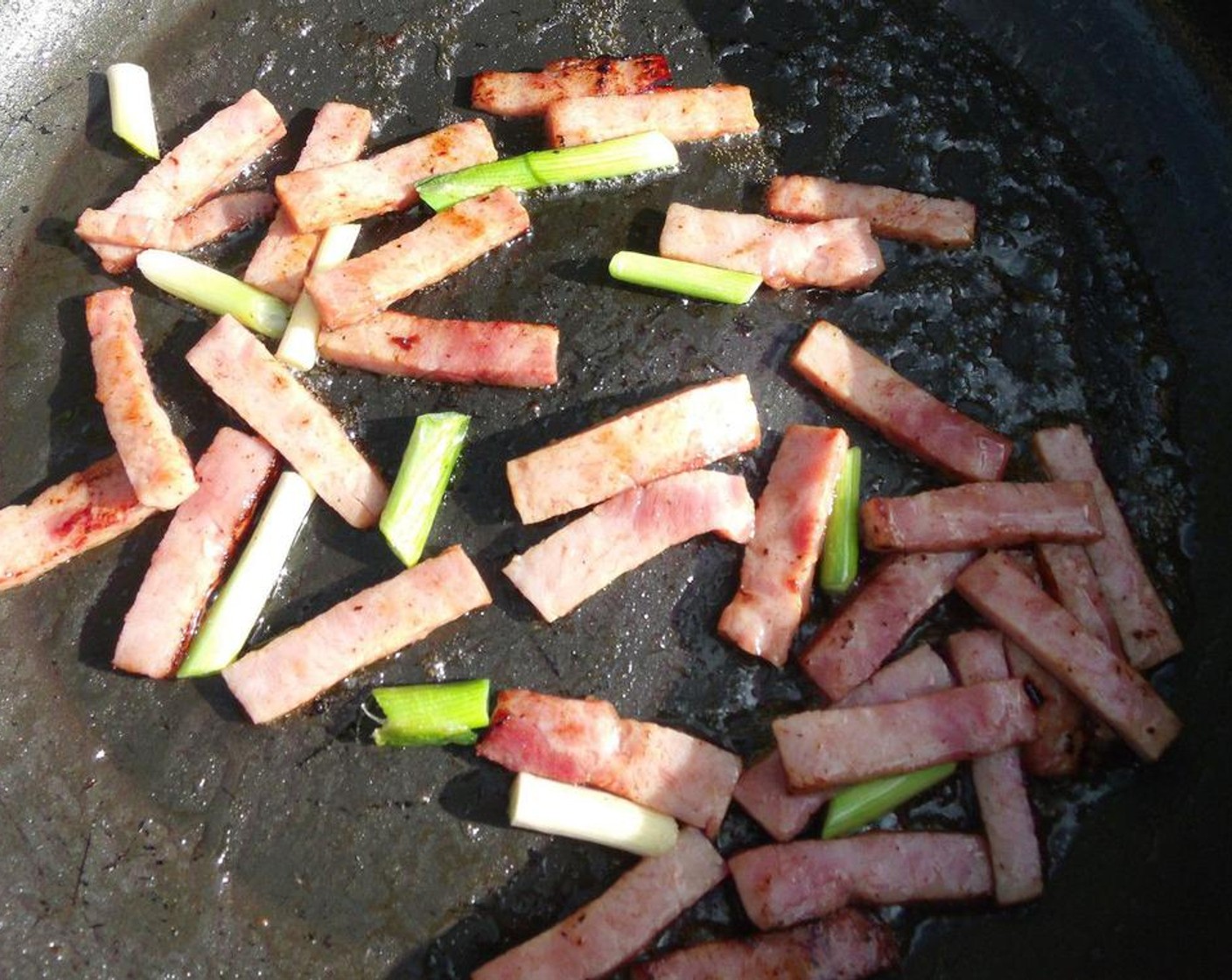 step 5 In the remaining oil, stir fry Cooked Ham (6 oz), Garlic Paste (1/2 tsp), Fresh Ginger (1/4 tsp), and Scallions (4 stalks). Stir fry until fragrant.