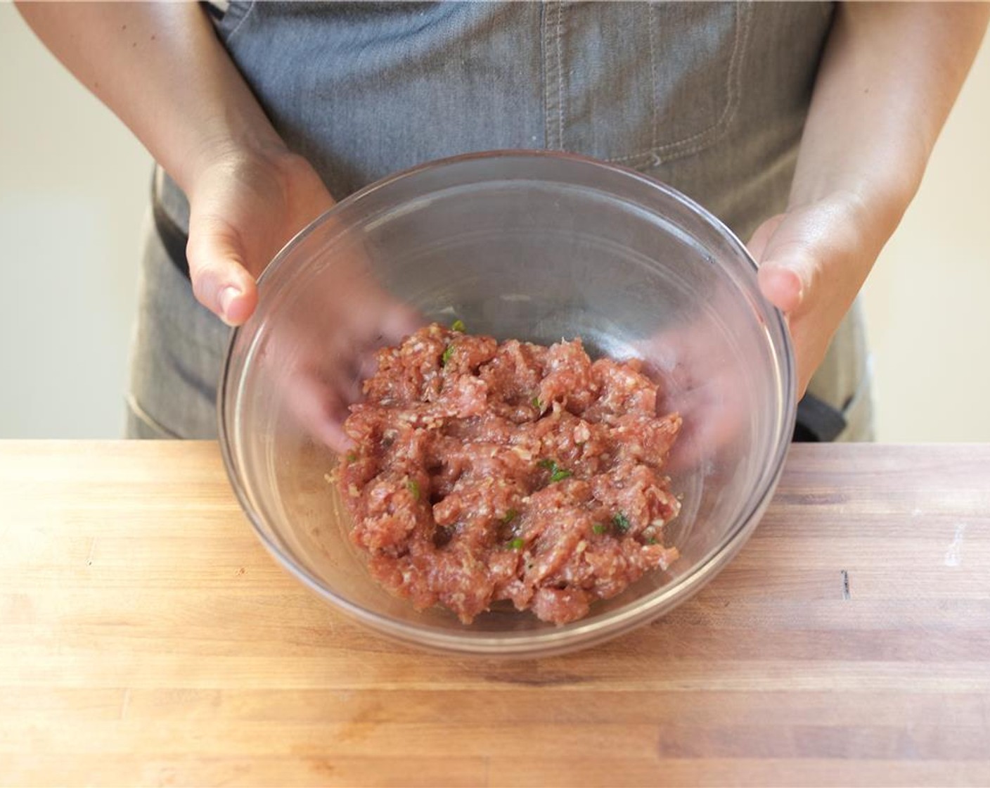 step 8 In another bowl, mix together the green onion, chopped ginger, the remaining garlic, Tamari Soy Sauce (2 cups) Ground White Pepper (1/4 tsp), one tablespoon of canola oil, Sesame Oil (1 Tbsp), the remaining sugar, and the Ground Pork Belly (8 oz). Mix until well combined.