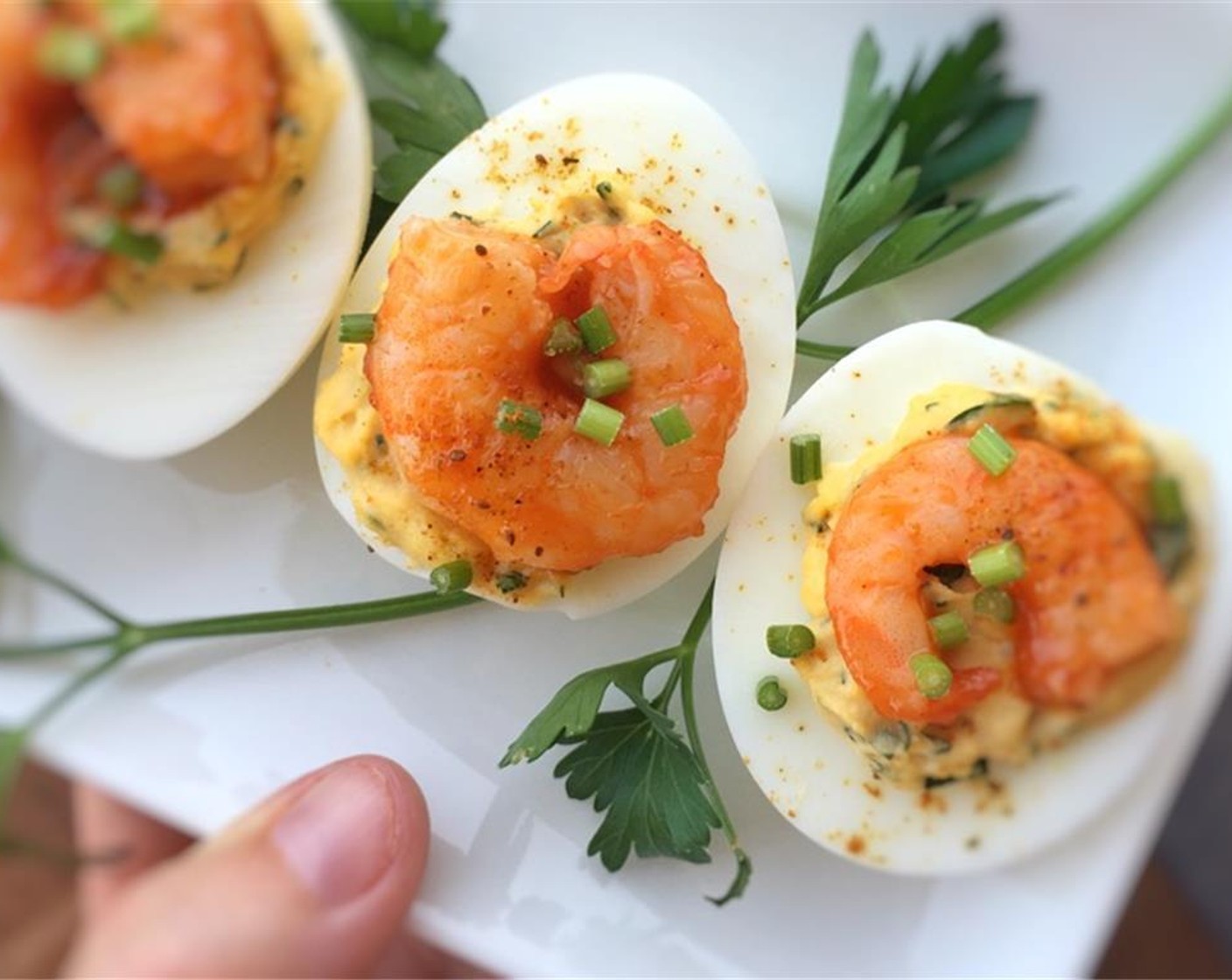 step 8 Fill the eggs evenly with the yolk mixture. Then top with a shrimp. Sprinkle with extra Old Bay seasoning and Fresh Chives (to taste).