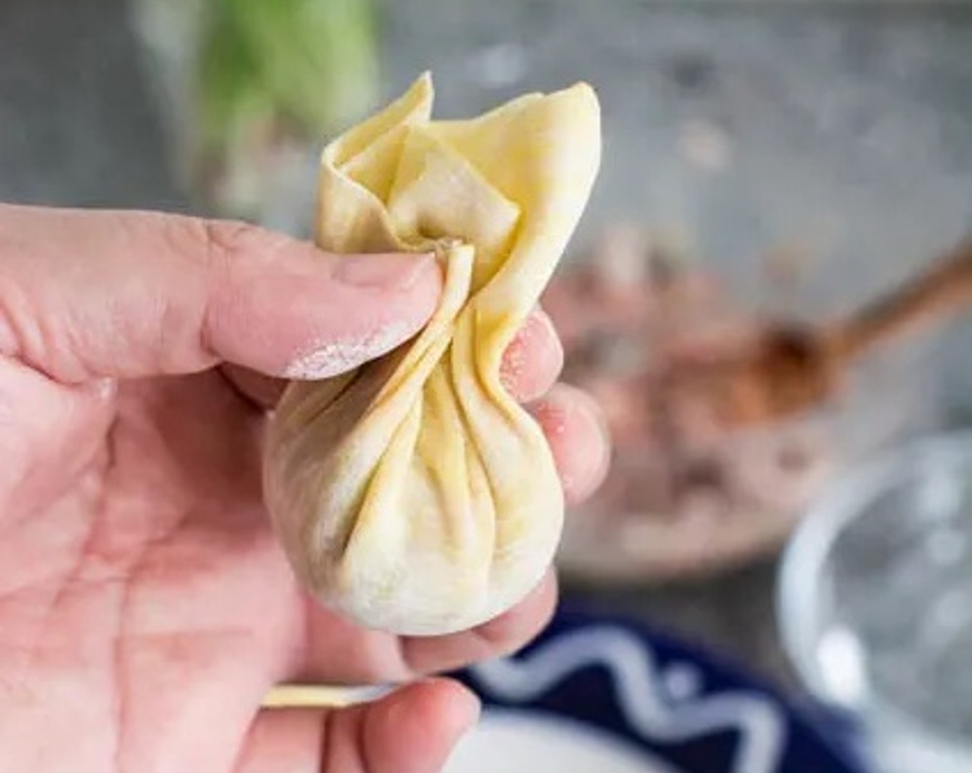 step 3 Gather the edges of the wonton wrapper towards the middle, then pinch just above the filling to seal it. Repeat until all of the filling is used up.