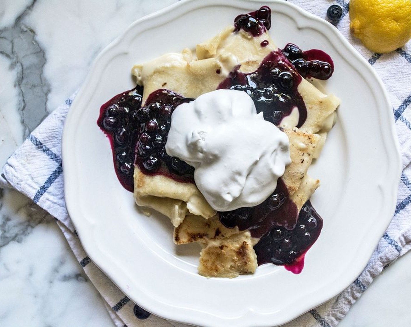 step 8 Once Blueberry Blintzes are lightly golden and slightly crispy, add to a plate. Top with blueberry compote and a dollop or two of coconut whipped cream, then serve!