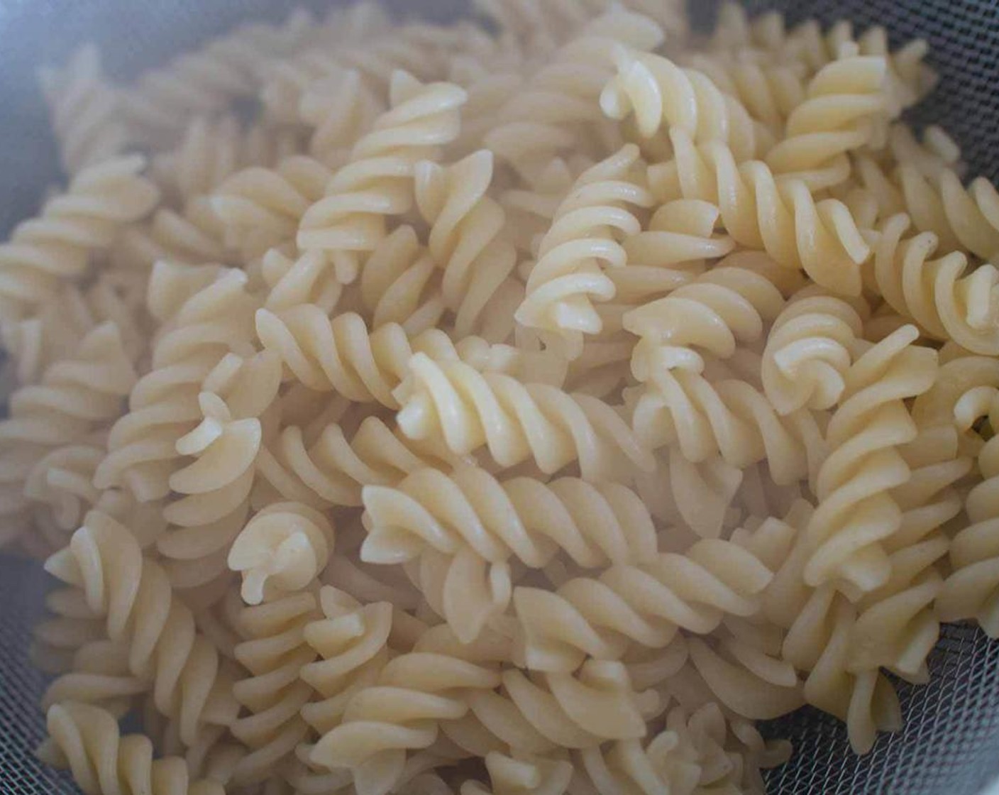 step 2 Rinse the fusilli with ice-cold water and drain thoroughly, shaking through a sieve to remove any excess liquid, set aside.