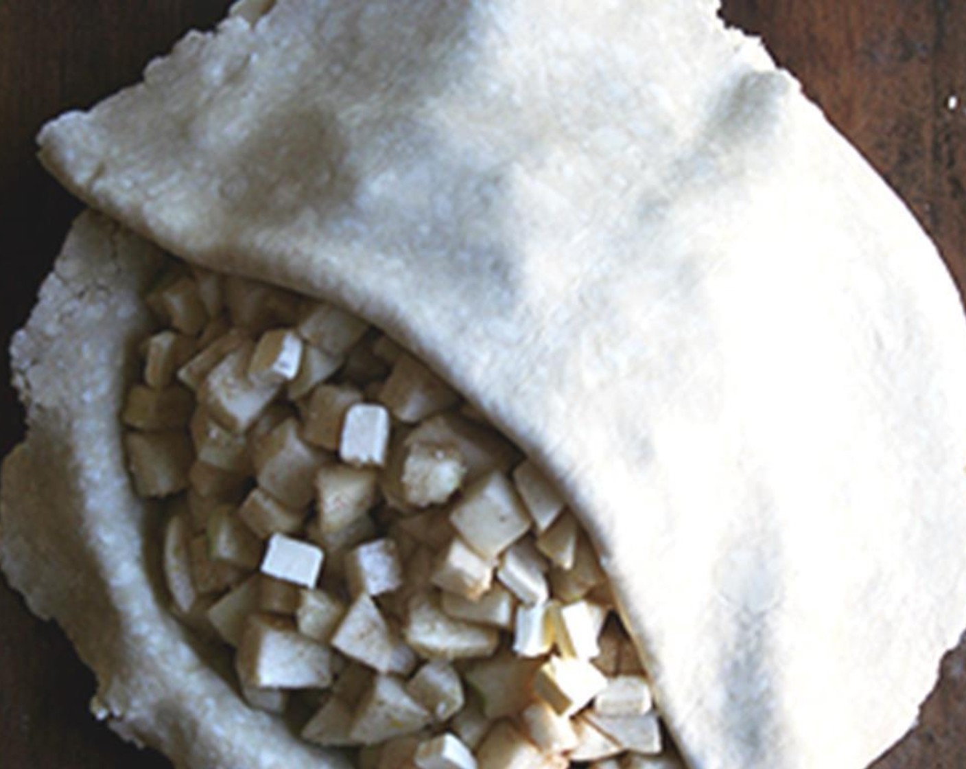 step 10 Lay the second round of pie dough over top. Using scissors, trim the overhanging dough and set aside.