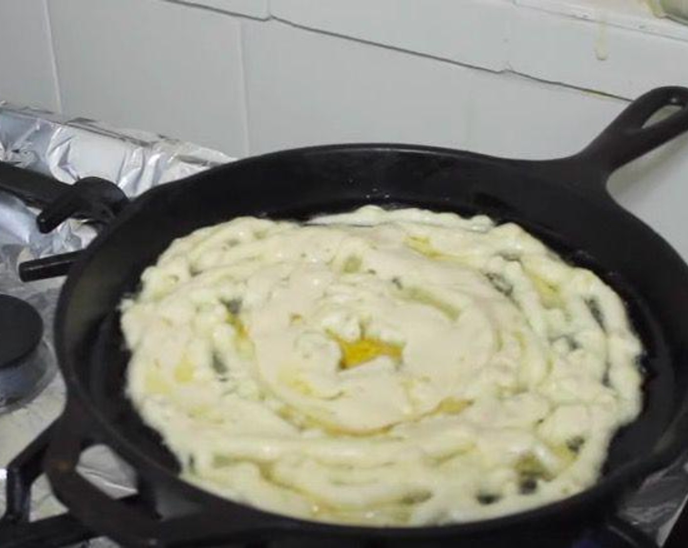 step 4 Pour some of the cake batter into a funnel and drizzle it in a round pattern in the hot pan. Cook the funnel cake for about 1-2 minutes, then flip.