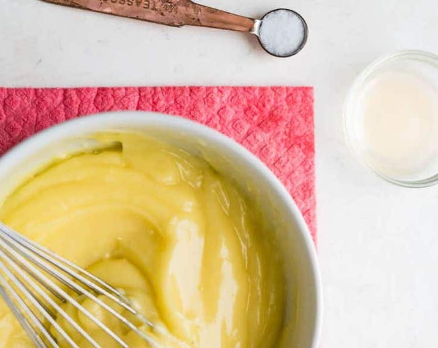 step 9 As the oil is whisked into the aioli, the mixture will start to emulsify. Continue to drizzle in the oil, whisking the entire time until all of the oil is incorporated.