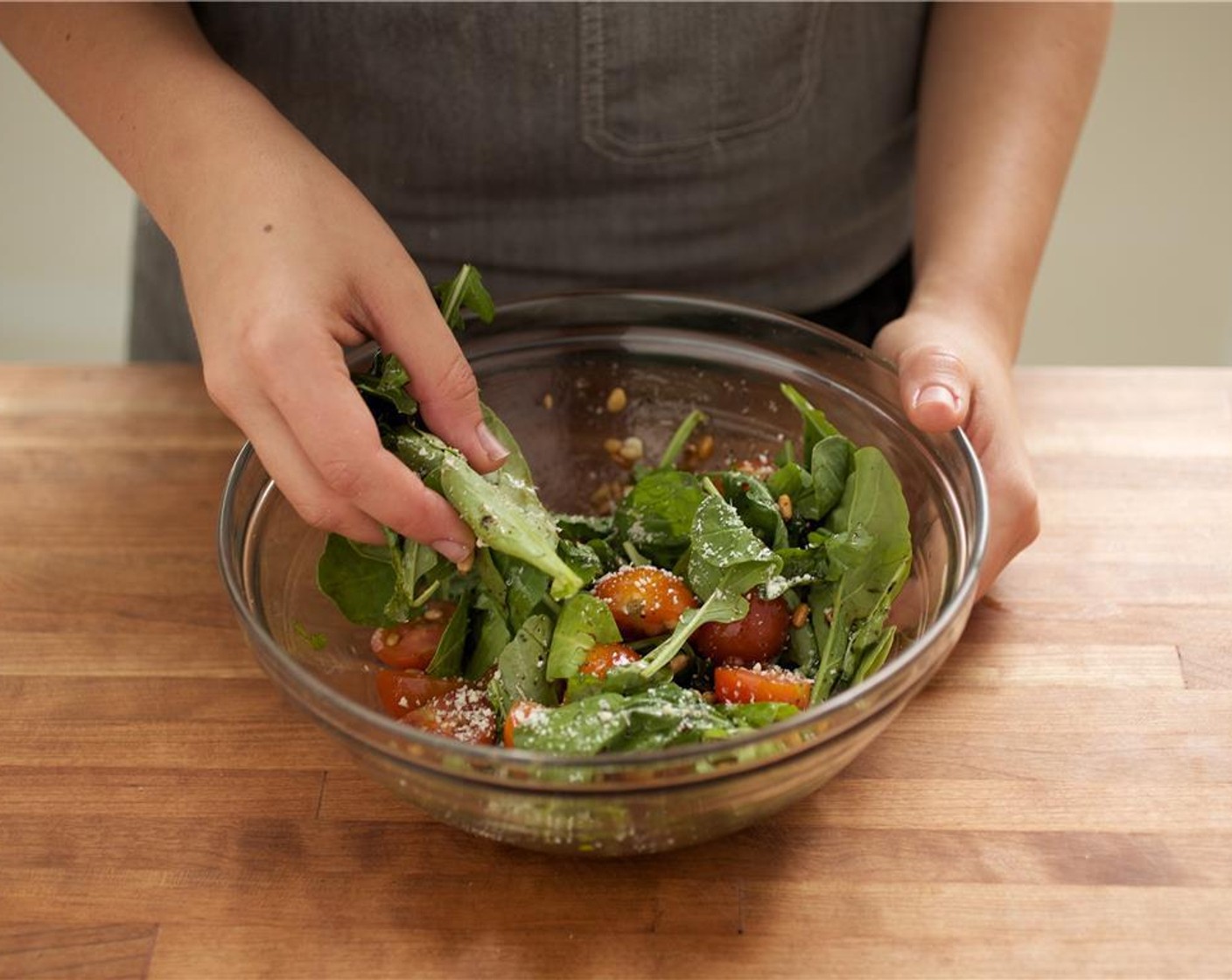 step 9 In the same large bowl as the vinaigrette, add the Arugula (2 3/4 cups), Pine Nuts (2 Tbsp), red cherry tomatoes, and remaining Parmesan Cheese (4 Tbsp). Mix until well combined.
