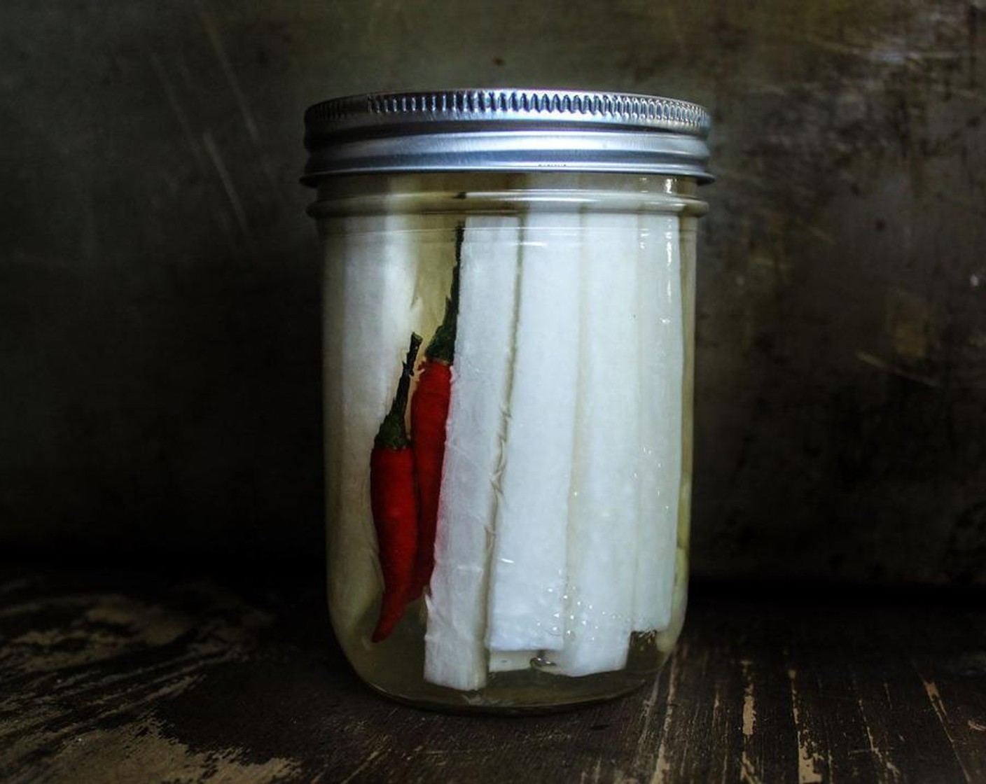 step 6 Add the daikon radish, the optional garlic, and Red Bird's Eye Chili Pepper (1) the container and cover with the warm brine. Seal the container well and keep it in the fridge for a minimum of 2 hours, preferably 24.