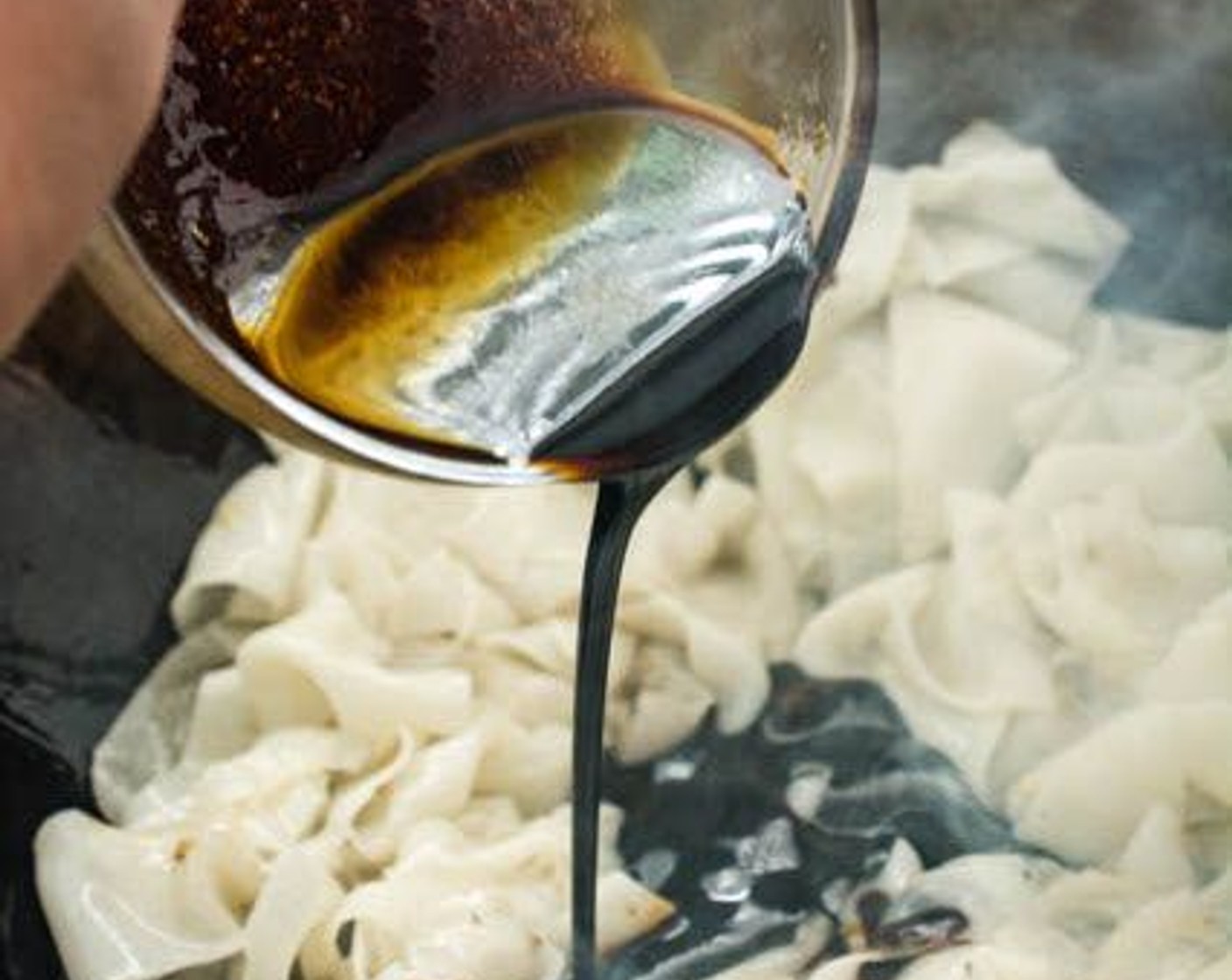 step 14 Stir the sauce, then pour the sauce over the noodles. Stir-fry the noodles, coating them evenly in the sauce.