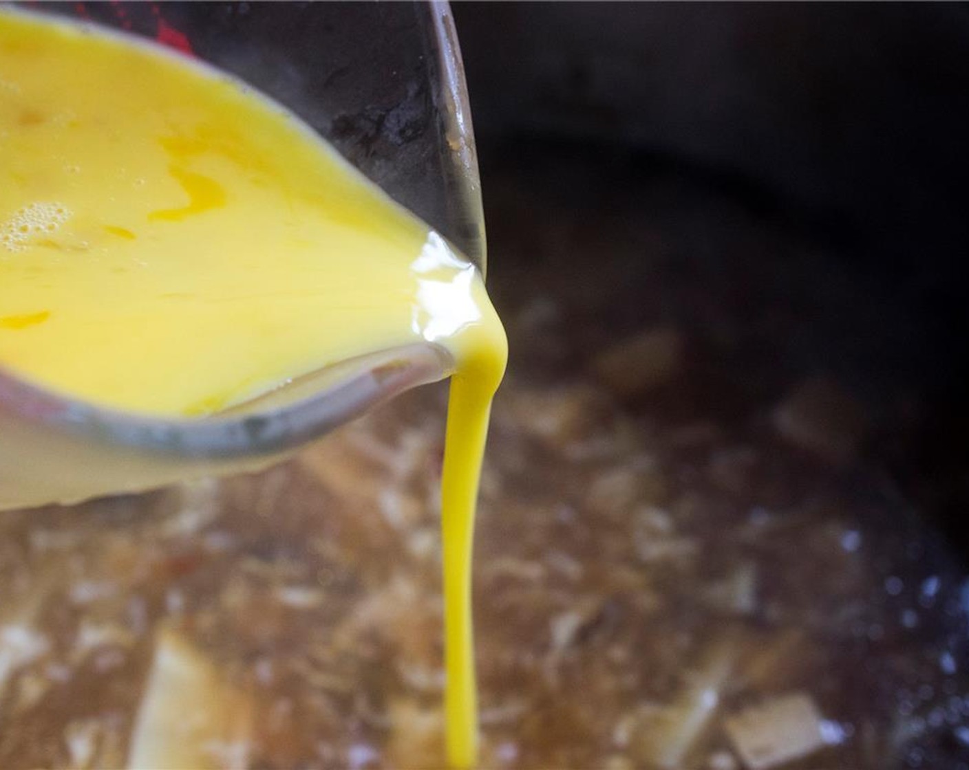 step 12 Stirring the soup in a circular motion, slowly drizzle in the beaten Eggs (2).  You want the egg to form wispy strands, not clumps.