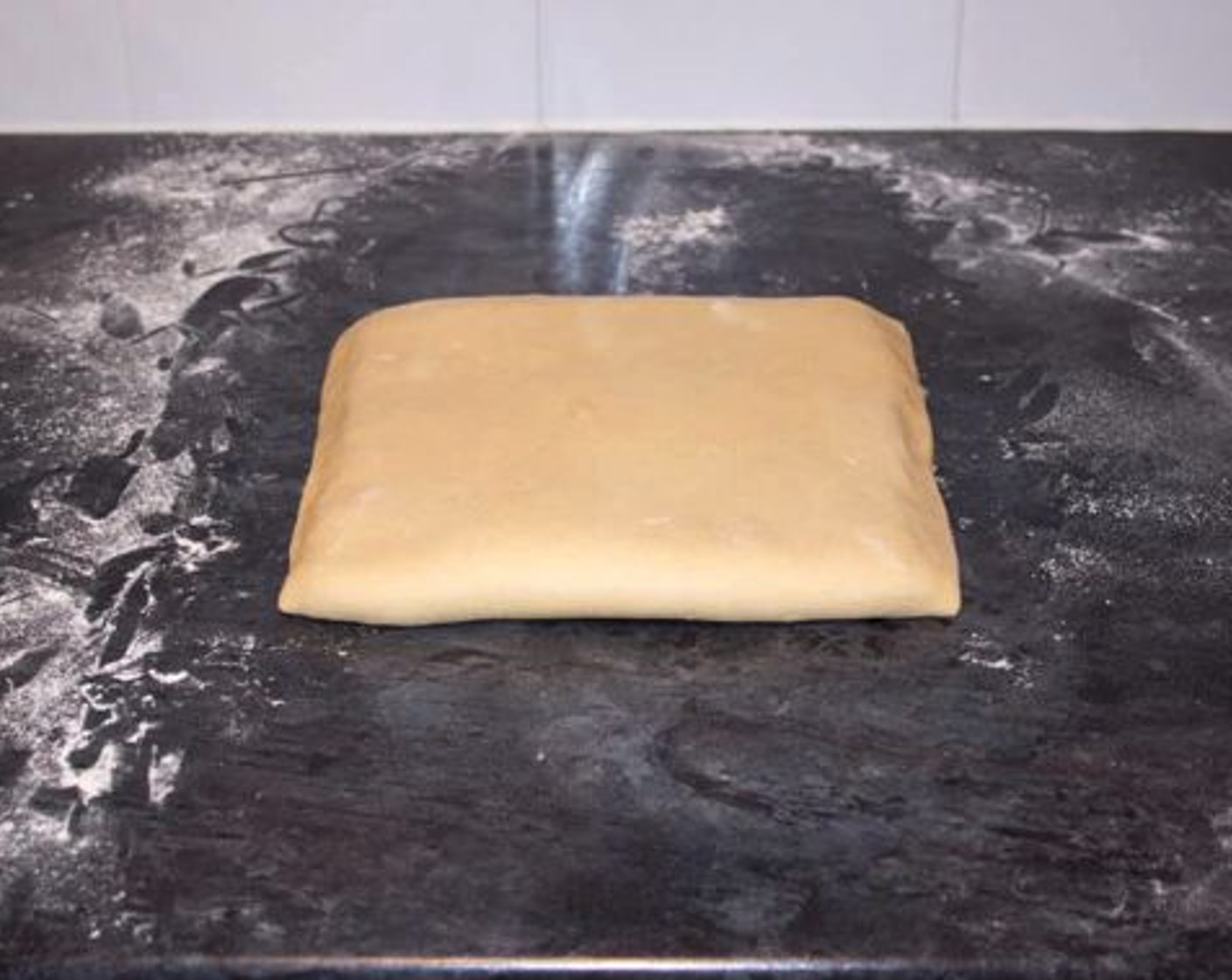 step 10 Now fold the exposed third of dough up over the top of the butter. Pinch the edges together lightly to seal and place back into the bag.