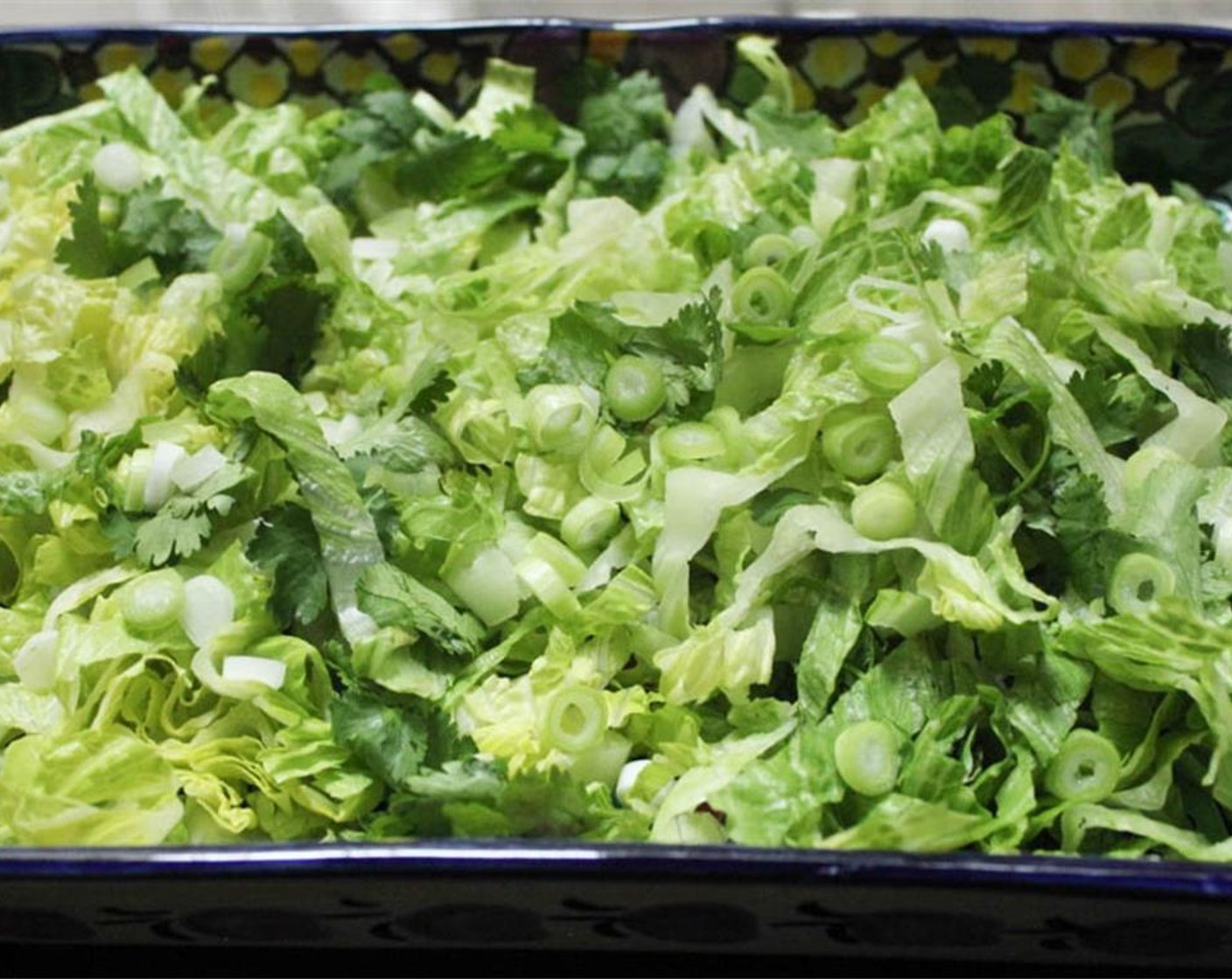 step 6 Place the Romaine Hearts (2), Scallion (1 bunch), Fresh Cilantro (4 Tbsp) in a large bowl or serving dish.
