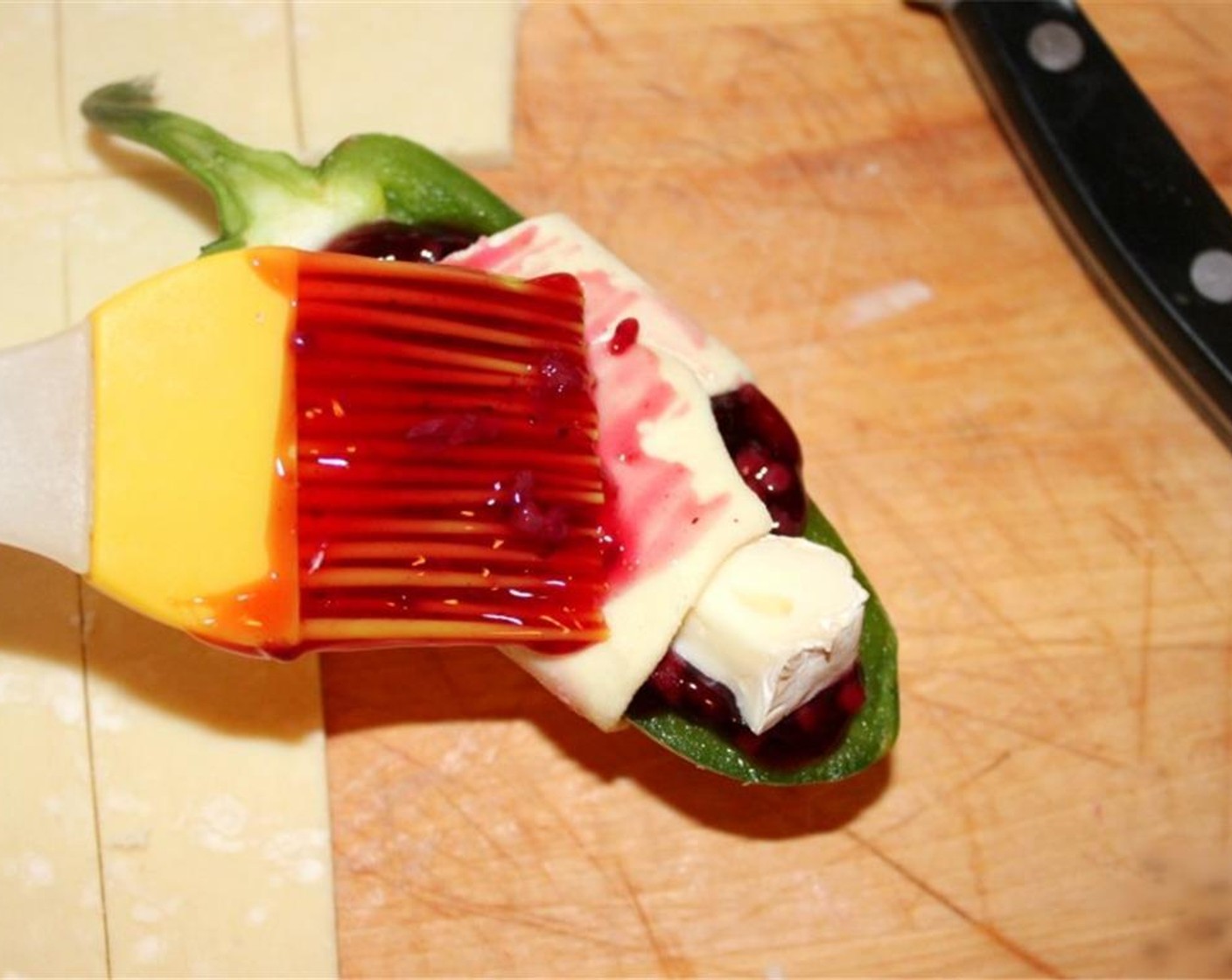 step 4 Wrap each filled pepper with a strip of puff pastry and brush them with some more pie filling. Then sprinkle the wraps with Granulated Sugar (200 g).