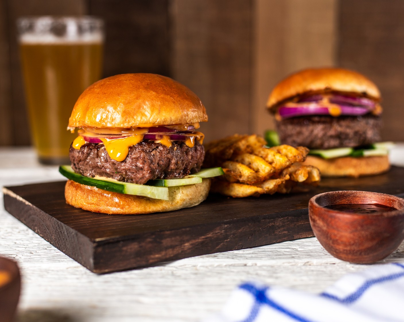 step 6 Build burgers by spreading Sriracha Mayonnaise (1/2 cup) on cut sides of buns. Add English Cucumber (1) to the base of the bun, then the burger patty. Add Red Onion (1 cup) to the top of the burgers and close with the other bun. Serve.