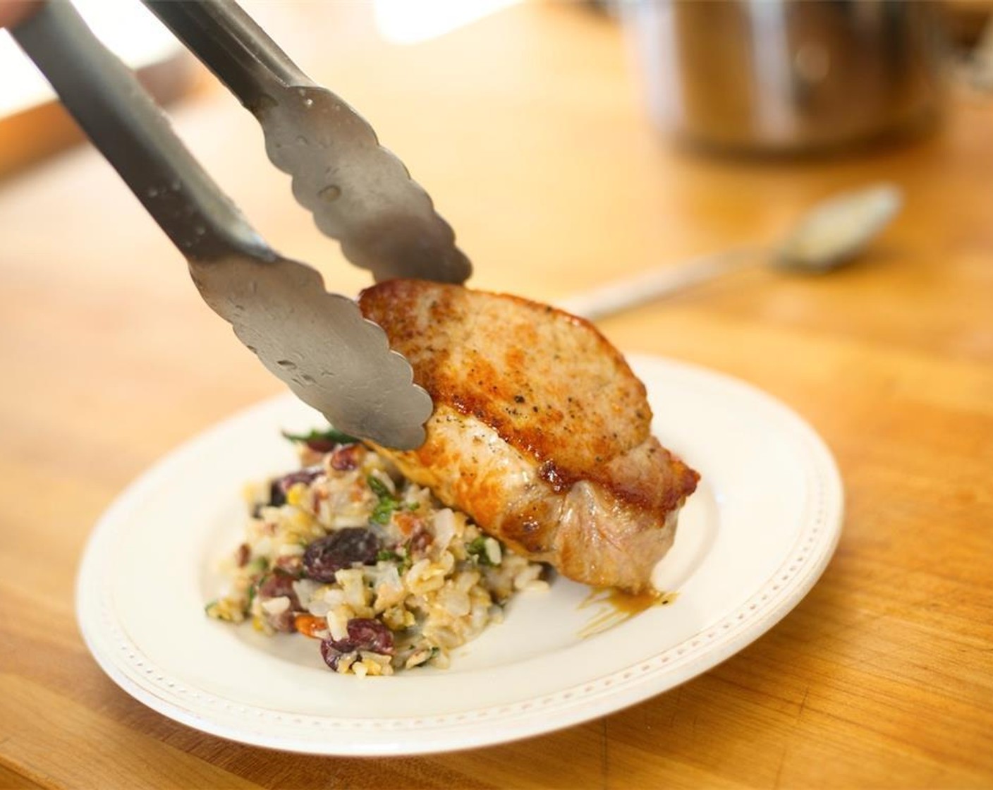 step 13 Divide the rice between two plates. Place the sauteed Swiss chard behind the rice with height. Lay the pork chops over the rice, leaning against the Swiss chard. Spoon the sauce over each chop.