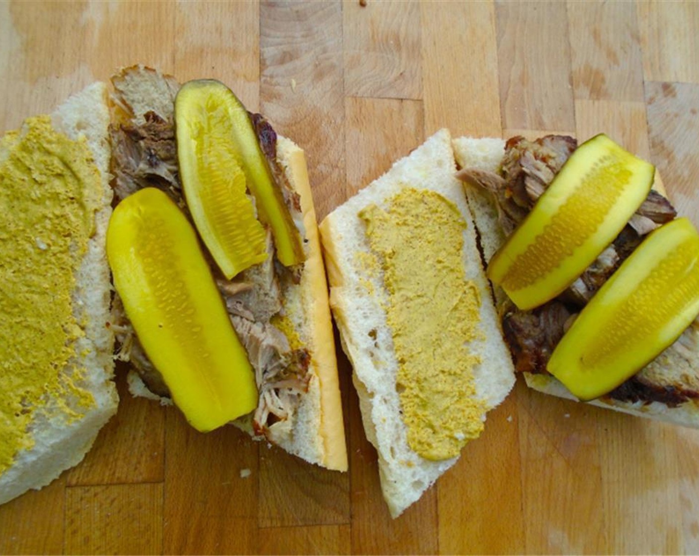step 6 Smear both sides of the fresh cuban breadwith Yellow Mustard (to taste), add a generous portion of the sliced pork shoulder, and add Pickle Slices (to taste).