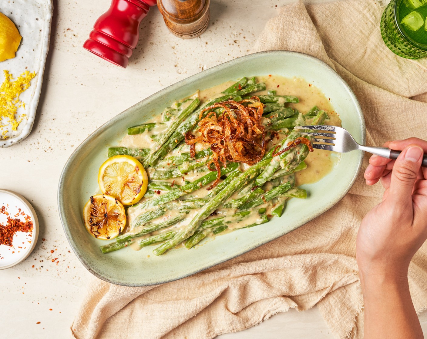 step 7 Transfer the miso-smothered green beans to a serving dish. Garnish with the zest from Lemon (1), Crushed Red Pepper Flakes (1 tsp), and sprinkle Fried Onions (to taste) for added crunch and contrast.