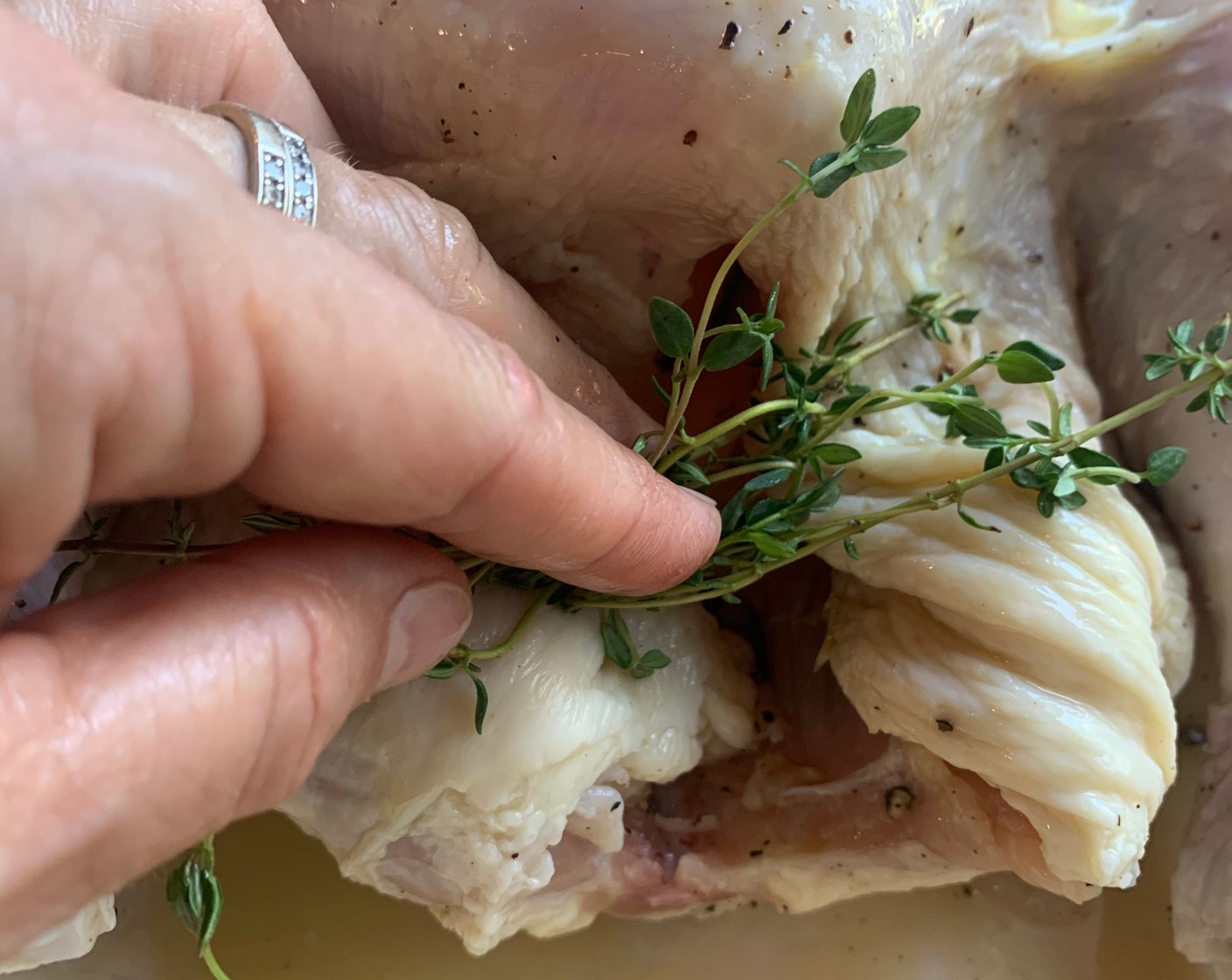 step 3 Place the Lemon (1/2) and the Fresh Thyme (4 sprigs) inside the cavity of the chicken and put it breast side down in a large roasting pan. Roast for 30 minutes.