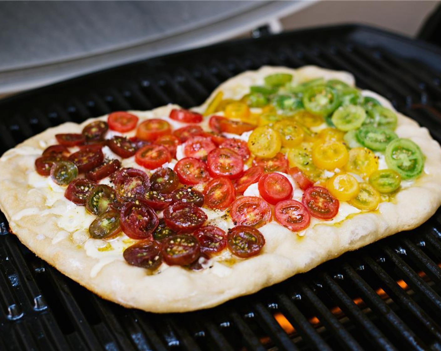 step 8 Layer Purple Grape Tomatoes (1 cup), Red Grape Tomatoes (1 cup), Yellow Grape Tomatoes (1 cup), and Green Grape Tomatoes (1 cup) onto the pizza in an ombre pattern.