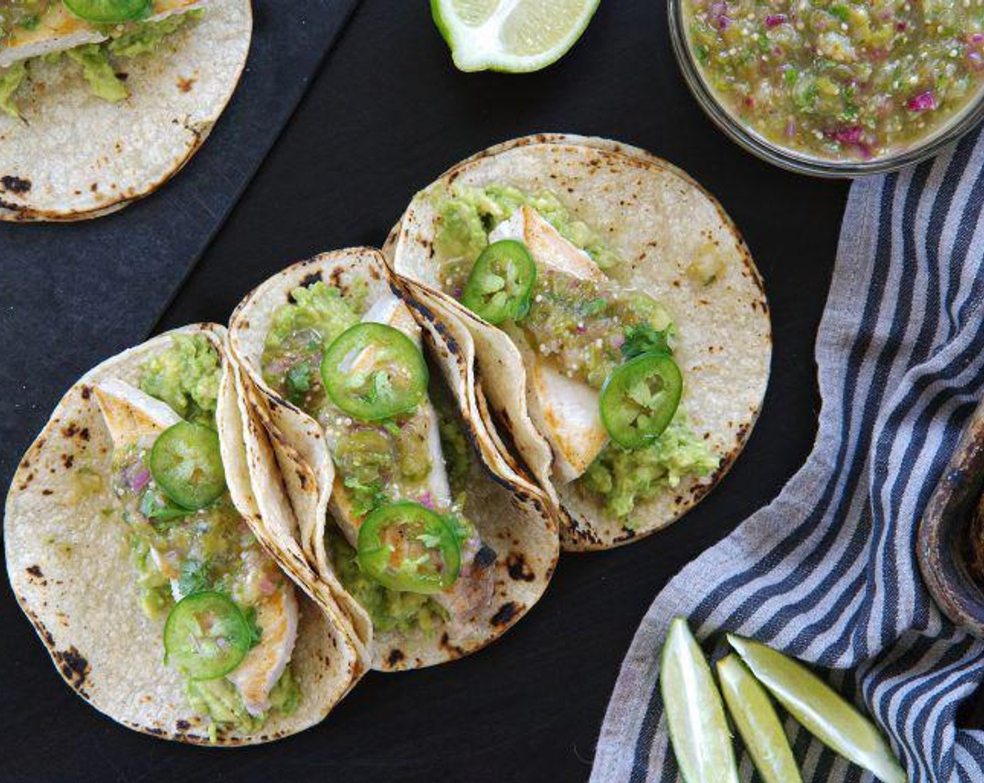 step 6 Layer your tacos as follows: 2 White Corn Tortillas (16), 1/8 of the Avocados (2), 1 piece of swordfish, and then 2 tablespoons of the tomatillo salsa. Serve with Lime (1) and Hot Sauce (to taste).