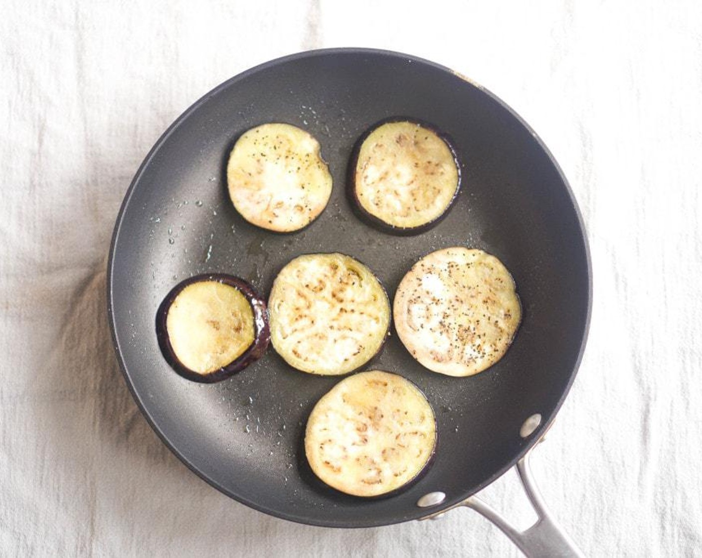 step 5 Heat Olive Oil (as needed) in a large sauté pan over medium-high heat. Add the eggplant slices in a single layer and cook for 2 minutes on each side.  Continue until all slices are par-cooked.